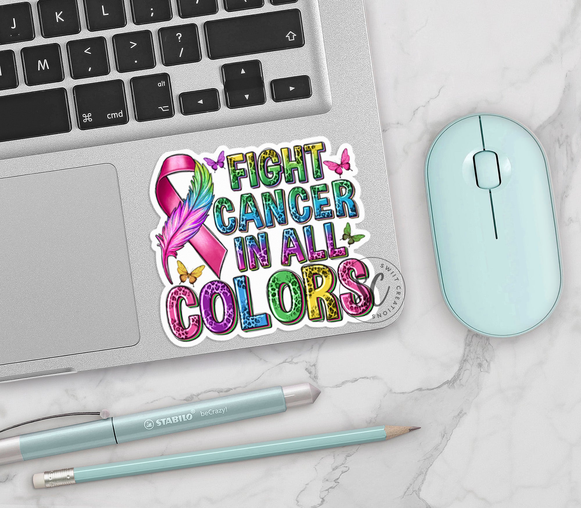 a computer keyboard, mouse, and sticker on a table