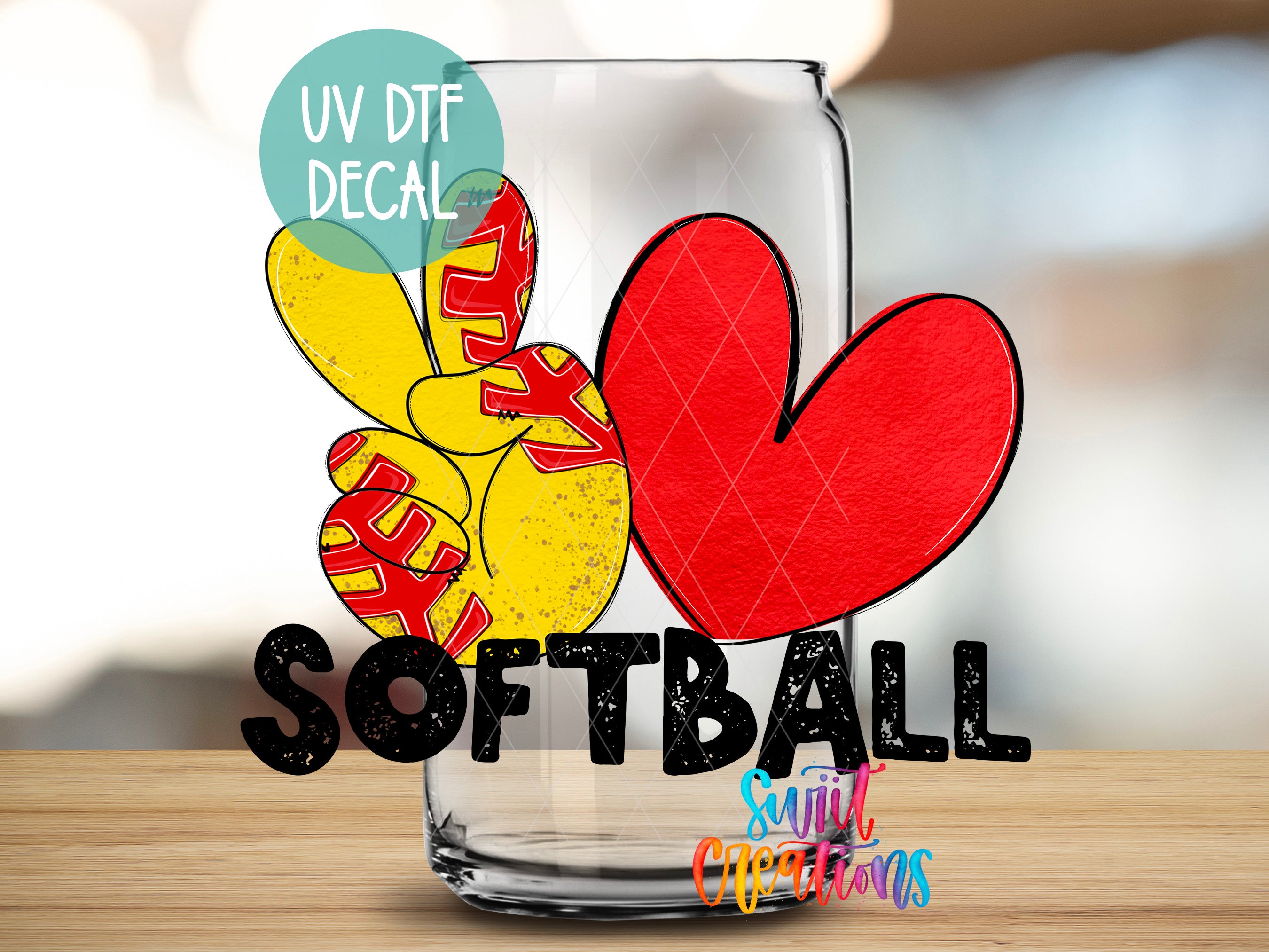 a glass with a heart and peace sign design, along with the text "SOFTBALL" and "Sunlit Creations" written on it.