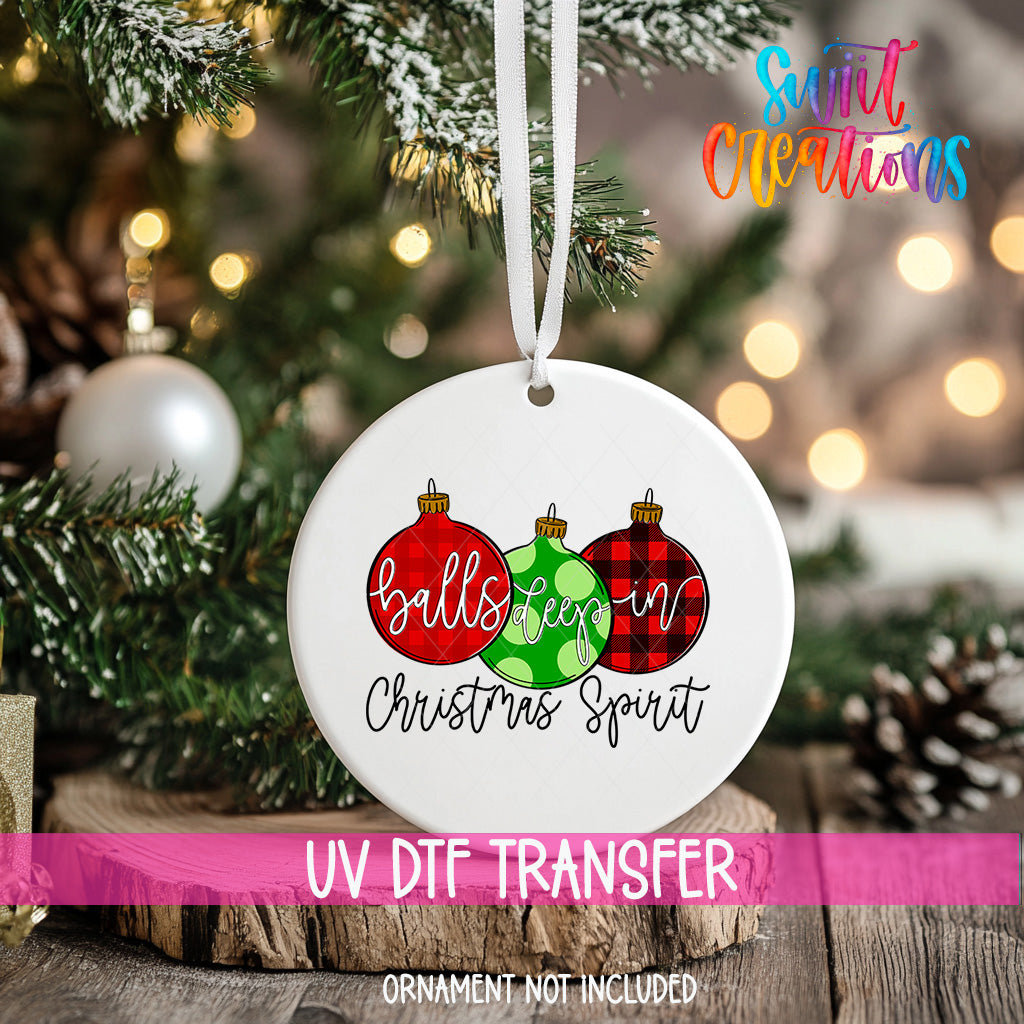 A white ceramic ornament with a festive design hangs on a Christmas tree, surrounded by pine branches and twinkling lights.