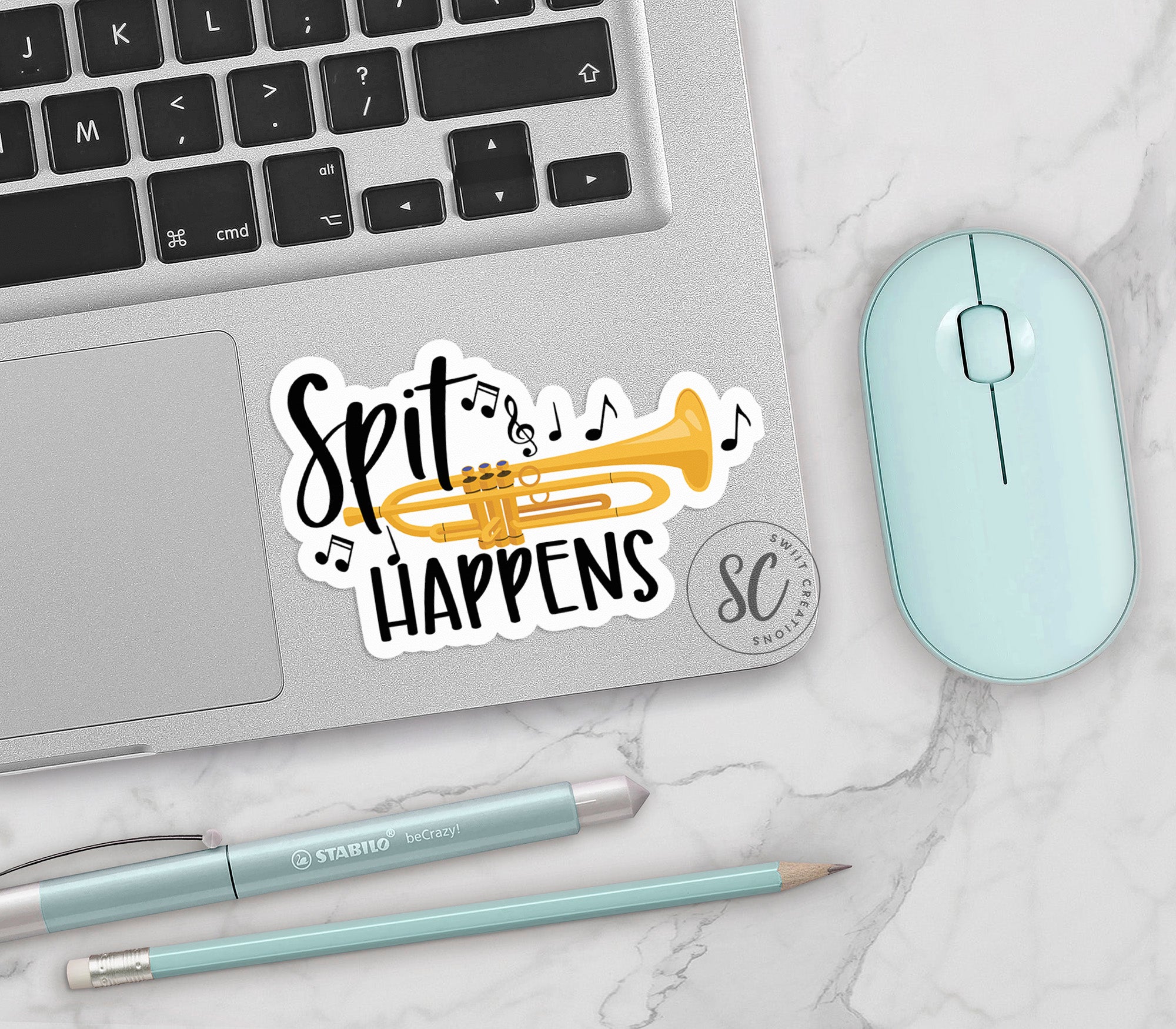 a sticker that says spit happens next to a mouse and keyboard