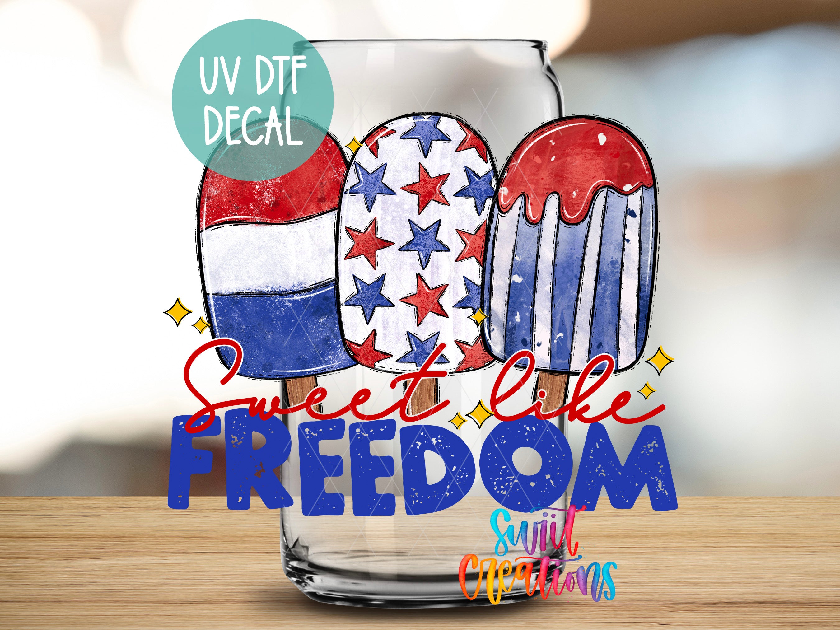 a glass with three colorful popsicles, each with a different design, and the text "Sweet like freedom" written on it.
