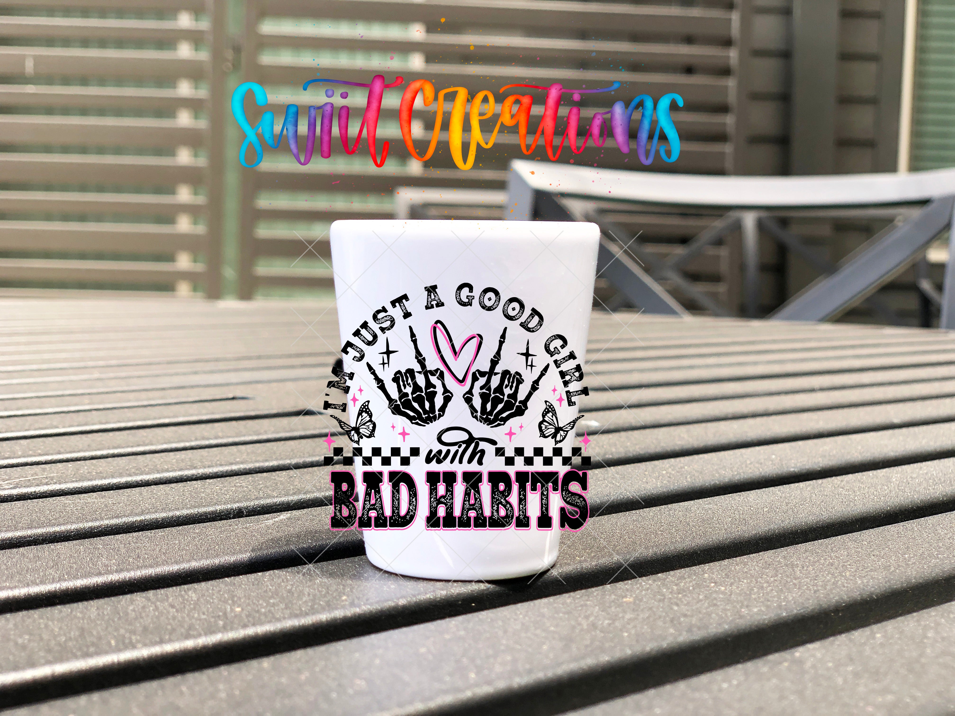 A white mug with a colorful graphic design and text on it, placed on a wooden surface.