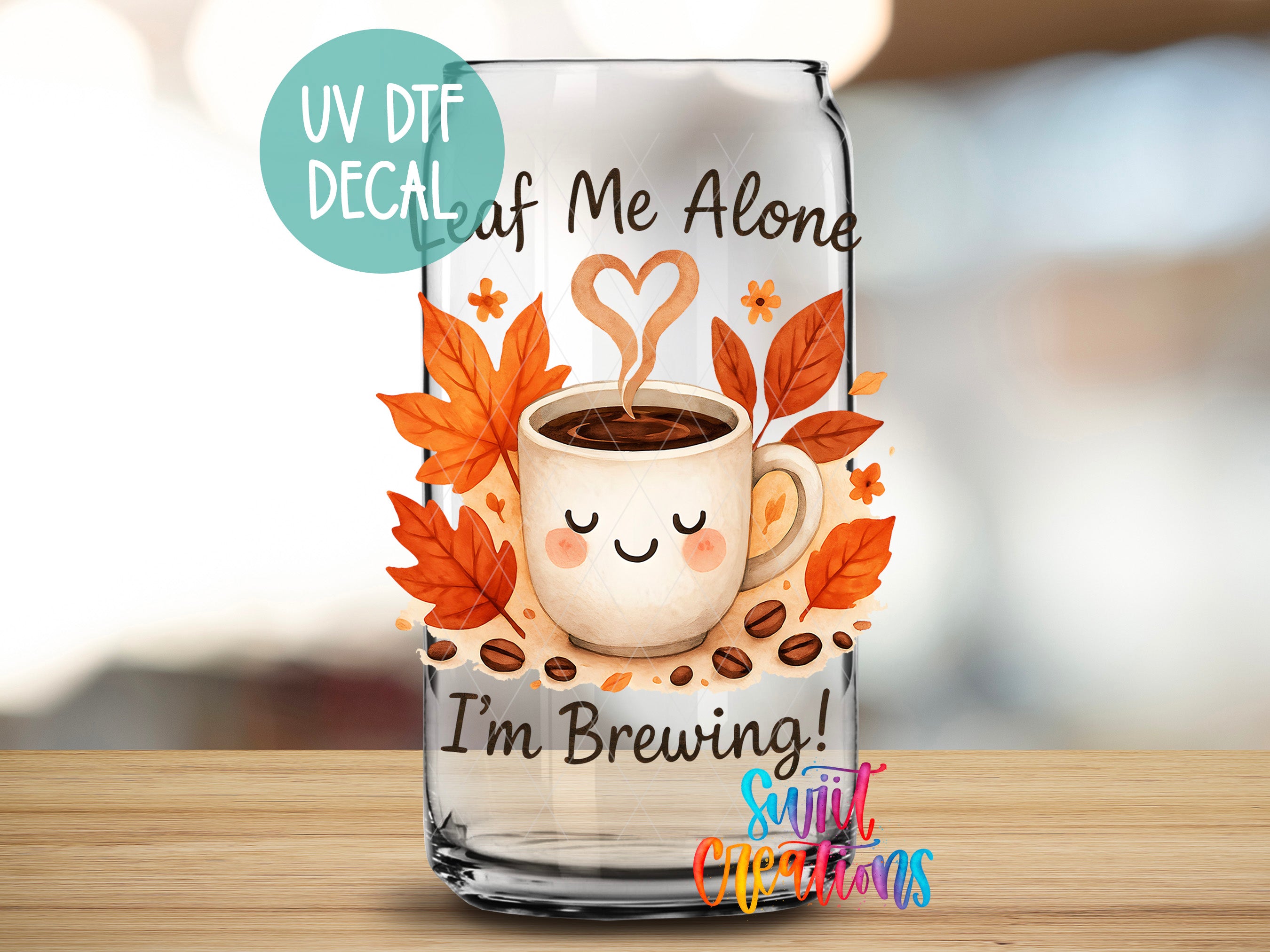A glass can with a cartoon image of a cup of coffee surrounded by autumn leaves and coffee beans, along with the text "UV Dtf DECAL Leaf of Me Alone I'm Brewing! Sunlit Occasions" printed on it.