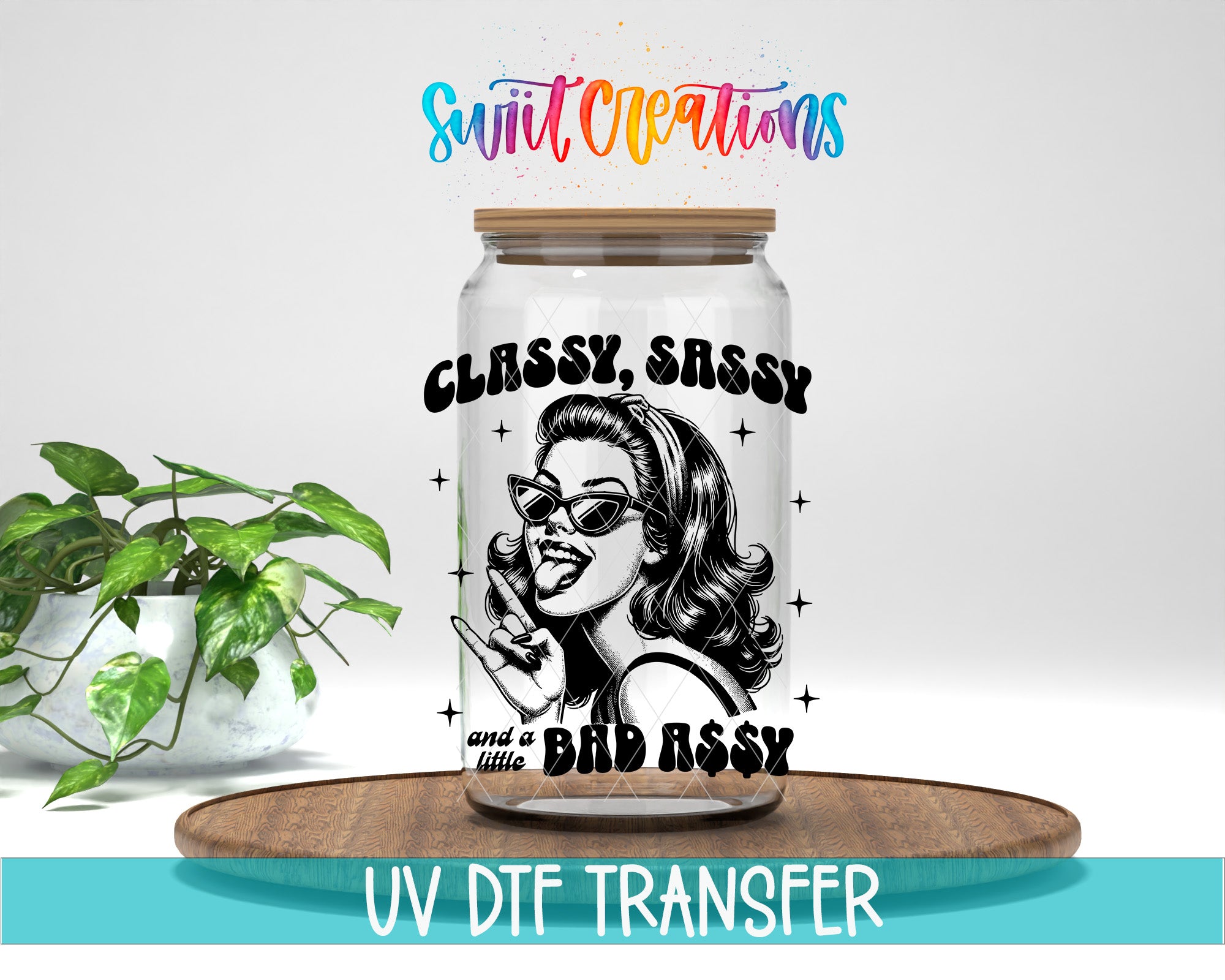 a glass jar with a black and white illustration of a woman wearing sunglasses, along with the text "CLASSY, SASSY and a BAD ASSY" printed on it. The jar is placed on a wooden surface, and there is a potted plant in the background.