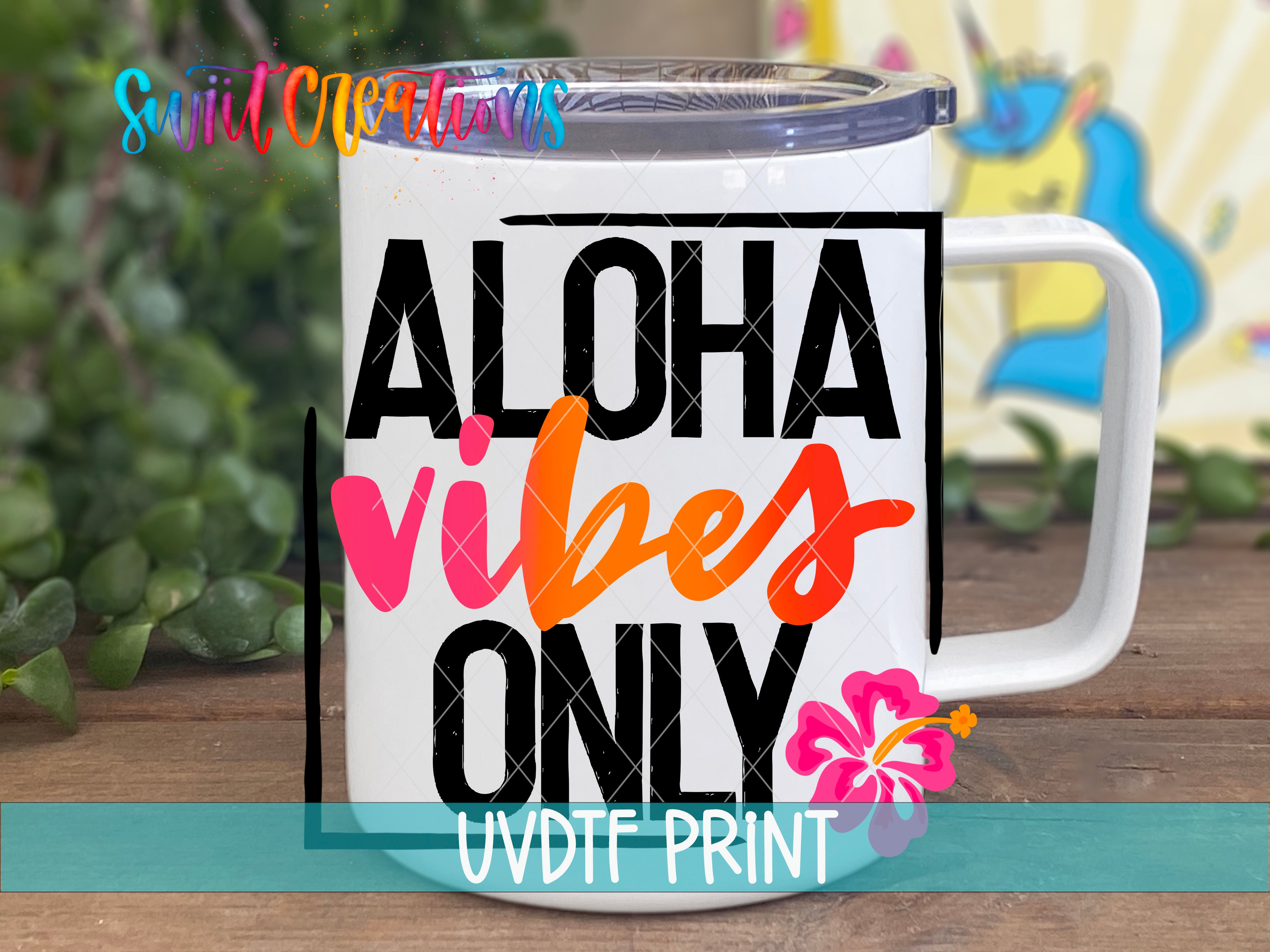 A white mug with the text "ALOHAS VIBES ONLY" printed on it, along with a pink flower design.