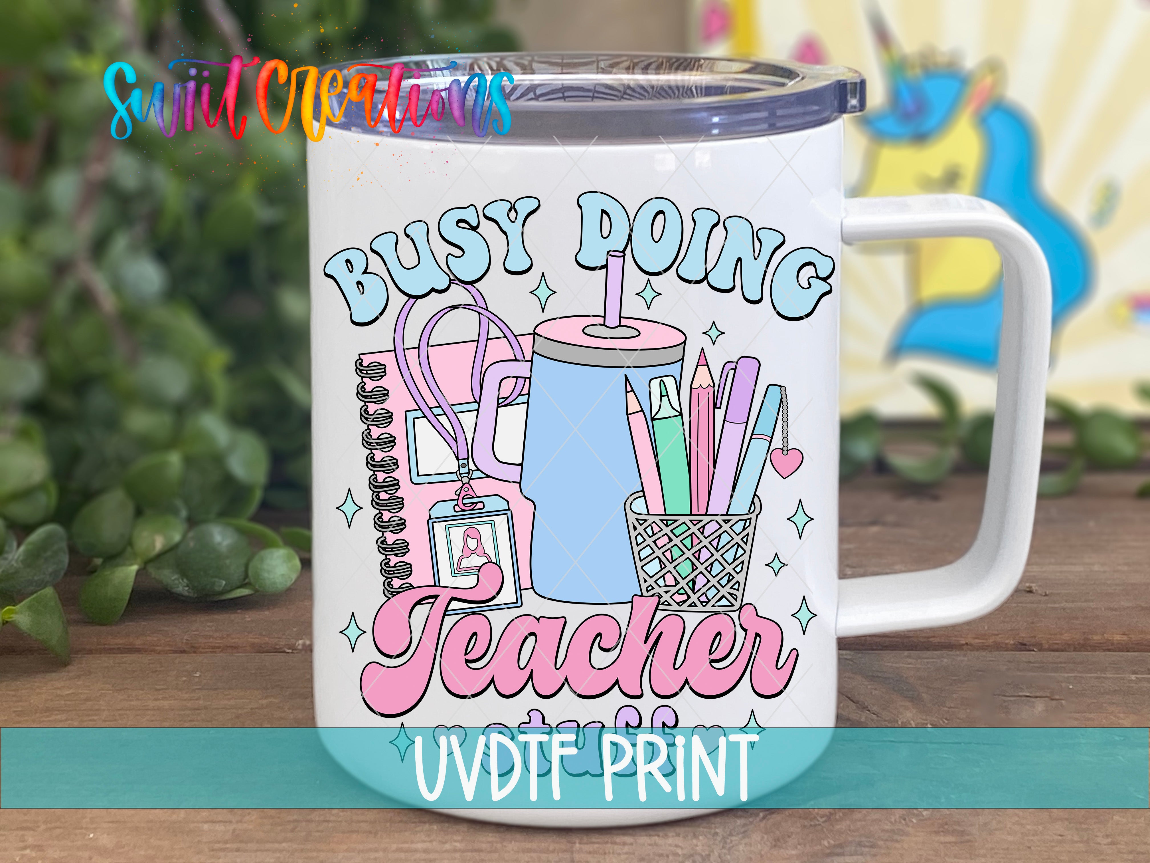A white mug with a colorful design featuring a teacher's desk, pencils, and a cup with a straw.
