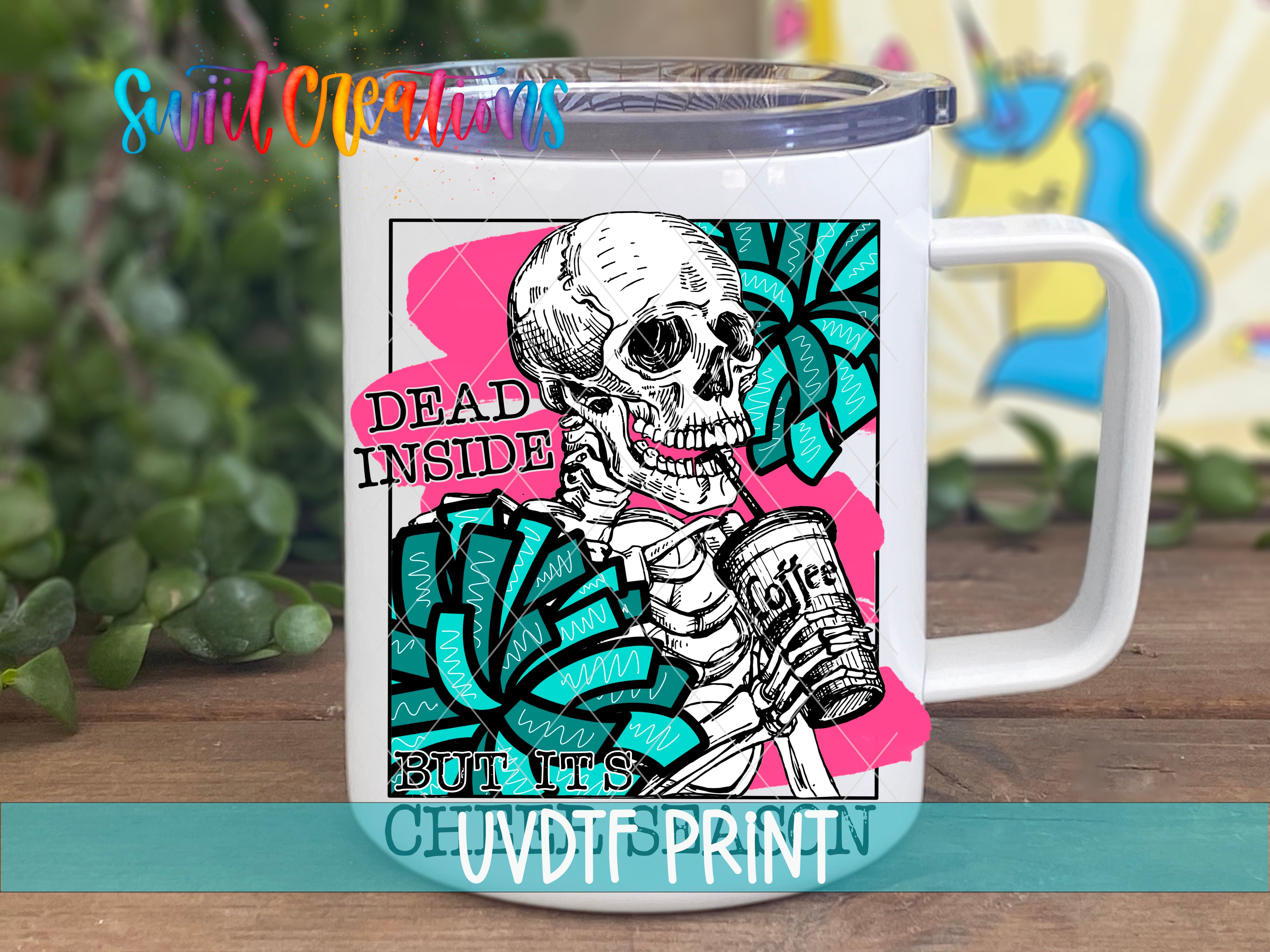 A white mug with a colorful graphic design featuring a skeleton holding a coffee cup, surrounded by various text elements.