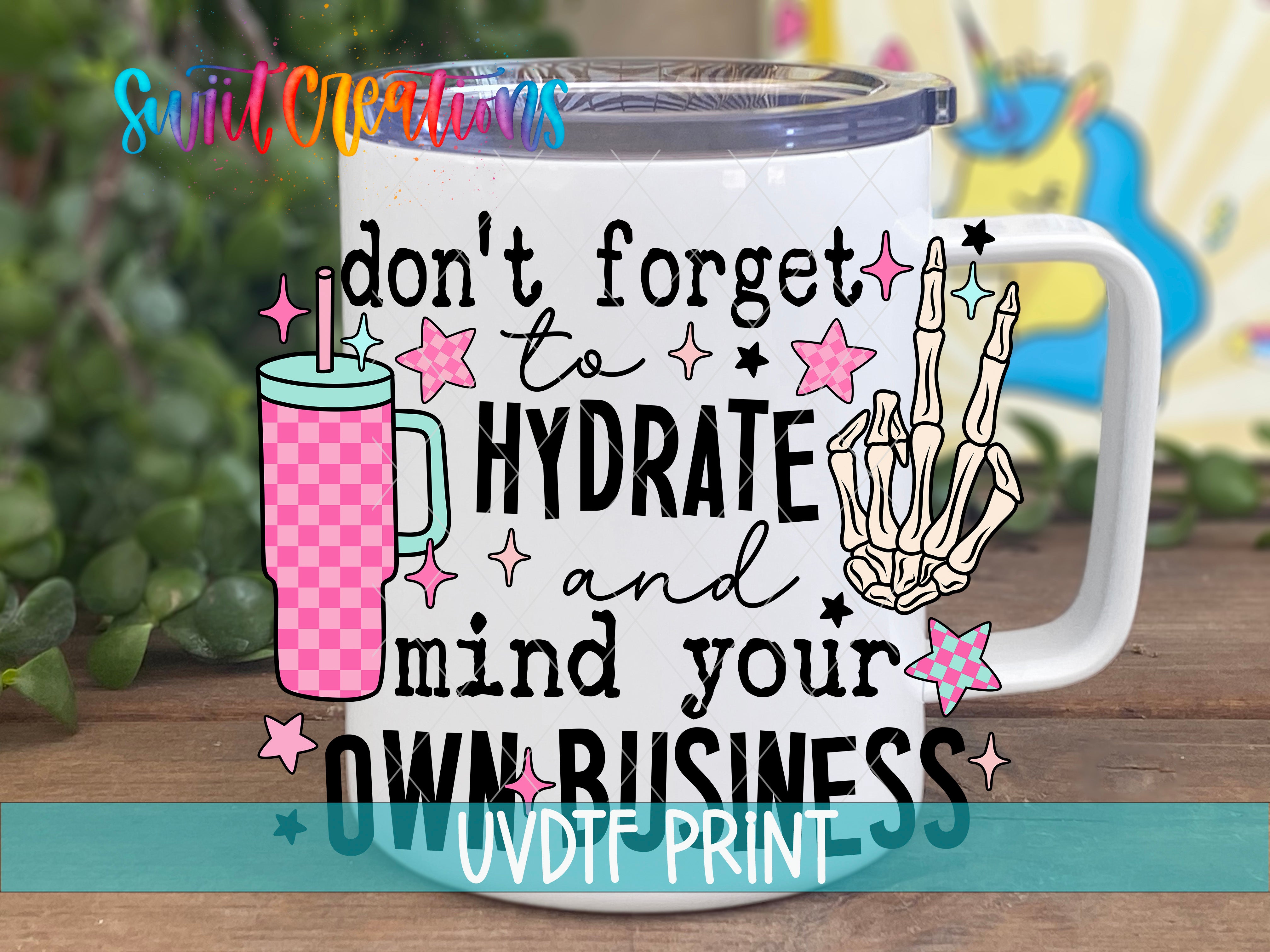 A white mug with a colorful design and text on it, placed on a wooden surface.