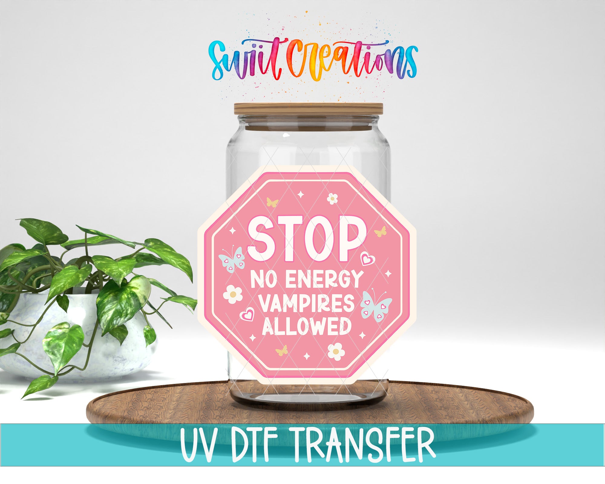 a glass jar with a pink sticker on it, placed on a wooden surface. The sticker has a message that says "STOP NO ENERGY VAMPIRE ALLOWED". There is also text at the bottom of the image that says "UV DFT TRANSFER".