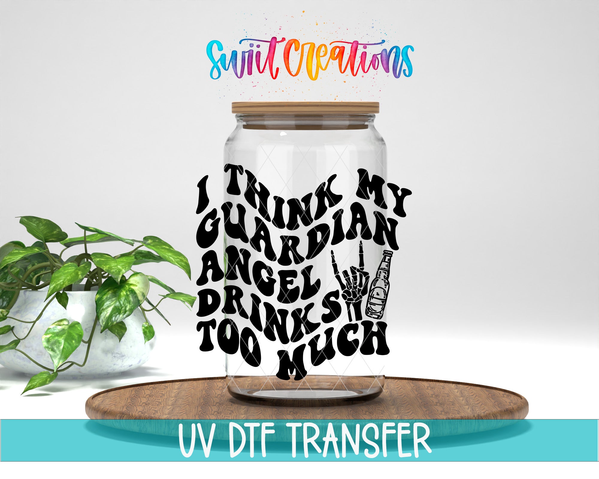 a glass jar with a hand-drawn design on it, placed on a wooden surface. The jar has a wooden lid and is surrounded by a potted plant. The text on the jar reads "I THINK MY GUARDIAN ANGEL DRINKS TOO MUCH".