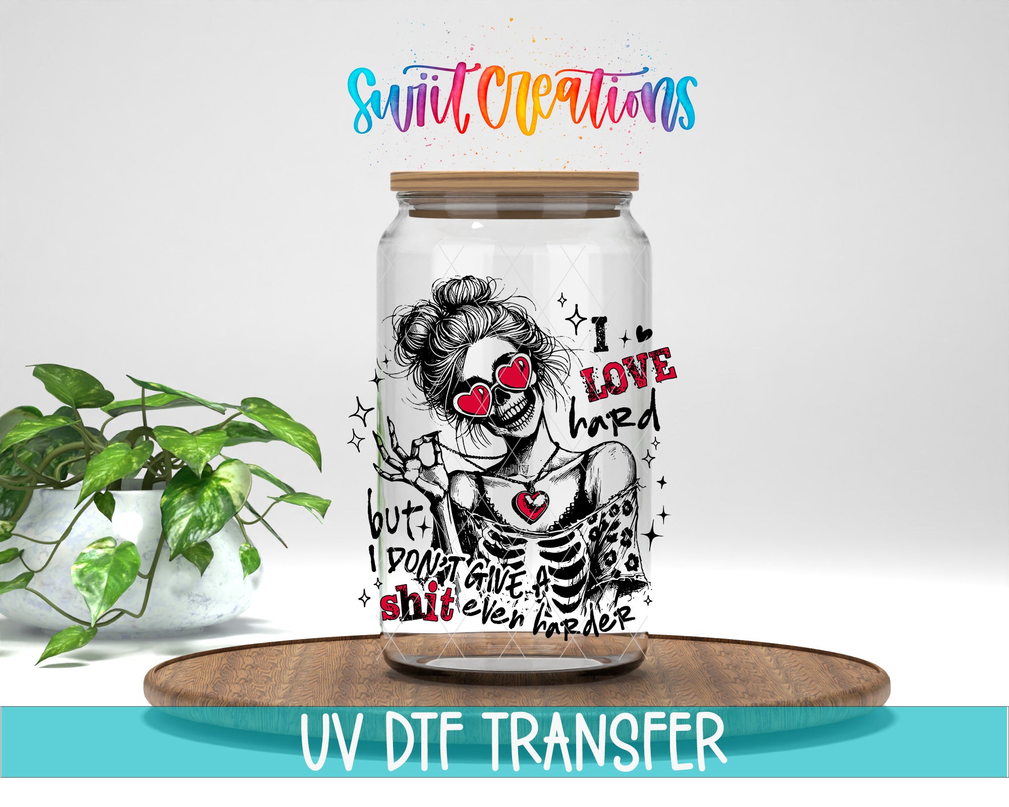 A glass jar with a colorful, artistic design featuring a woman with a skull-like face and text, placed on a wooden surface next to a potted plant.