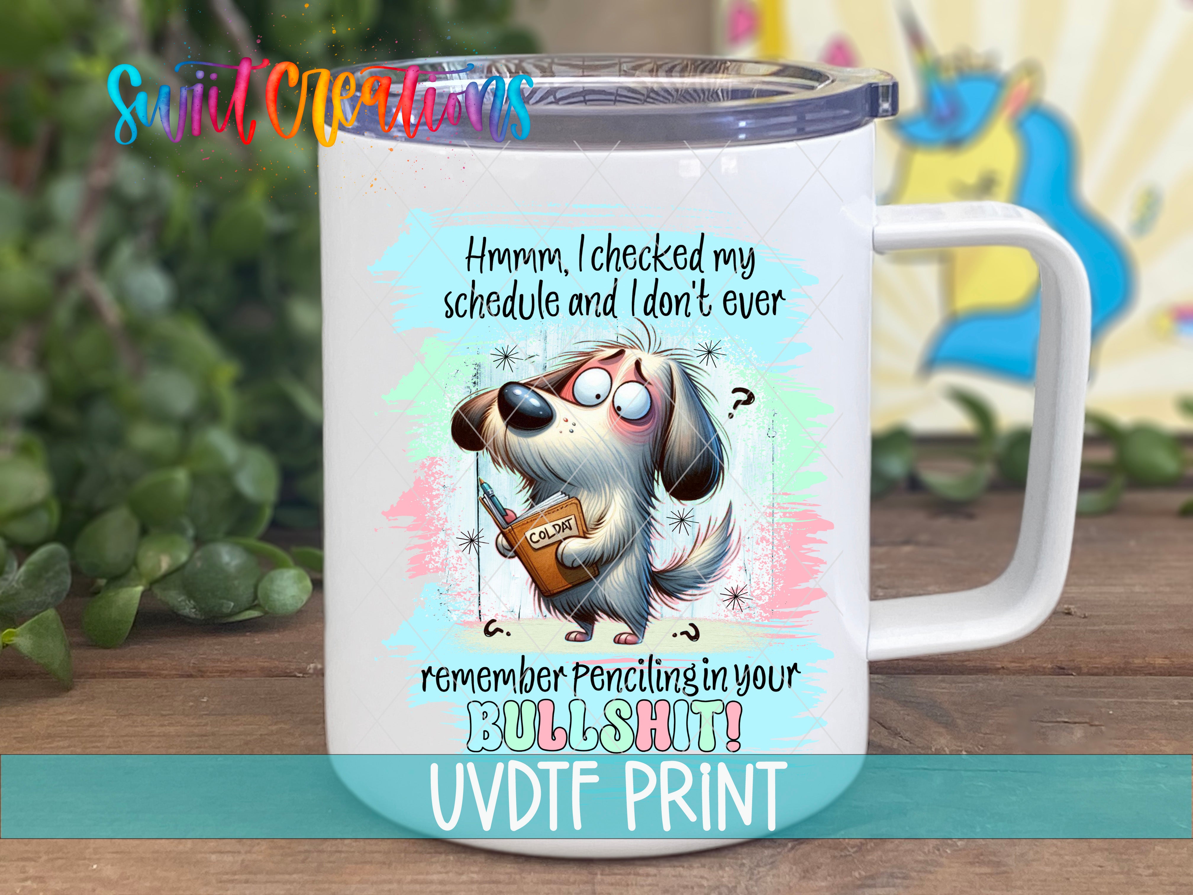 A white mug with a cartoon dog and text on it, placed on a wooden surface.