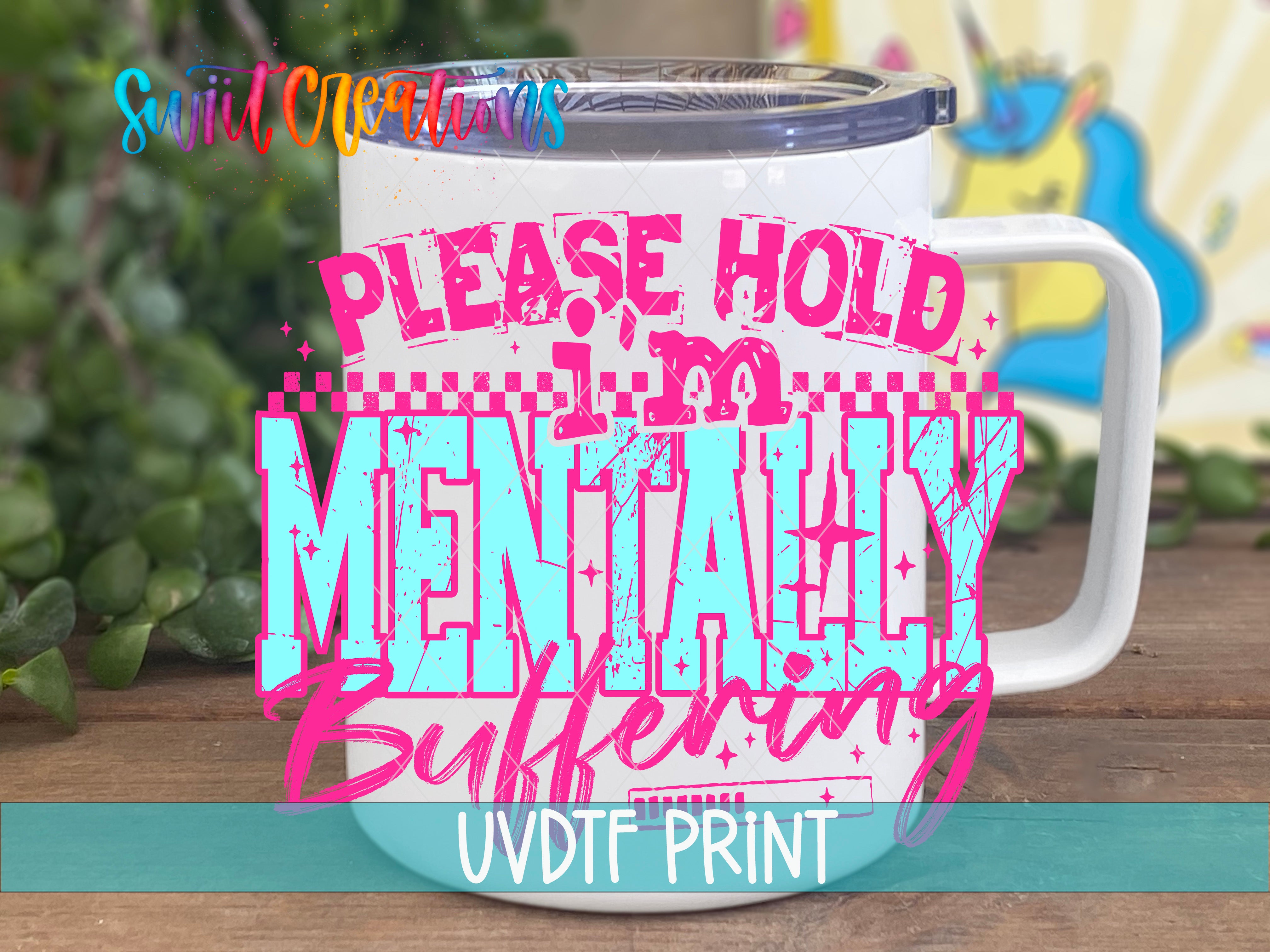 A white mug with a colorful graphic design featuring the text "PLEASE HOLD MENTALLY BUMPERING" in pink and blue letters.