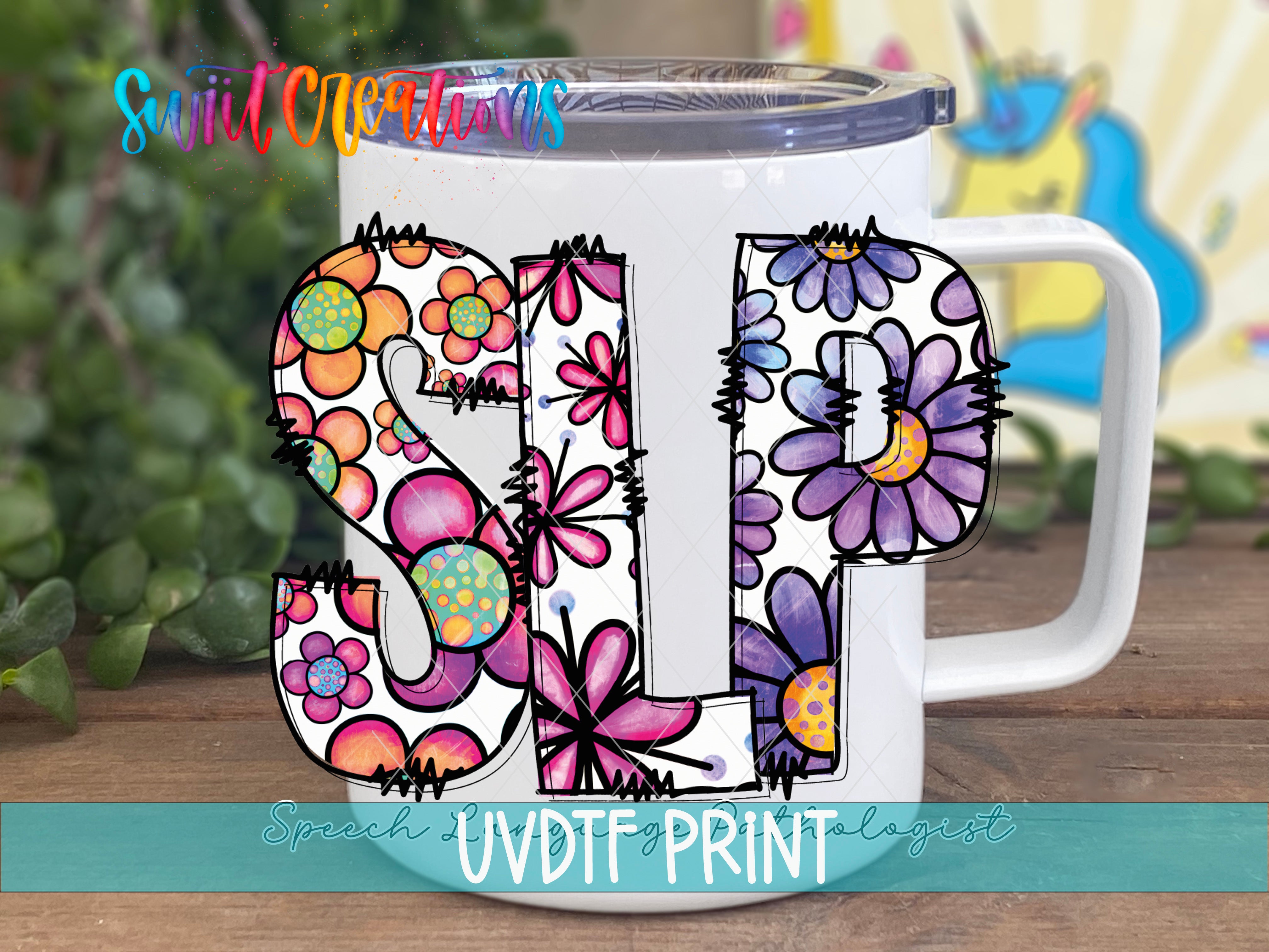 A white mug with colorful floral designs and the letters "SLP" printed on it, placed on a wooden surface.