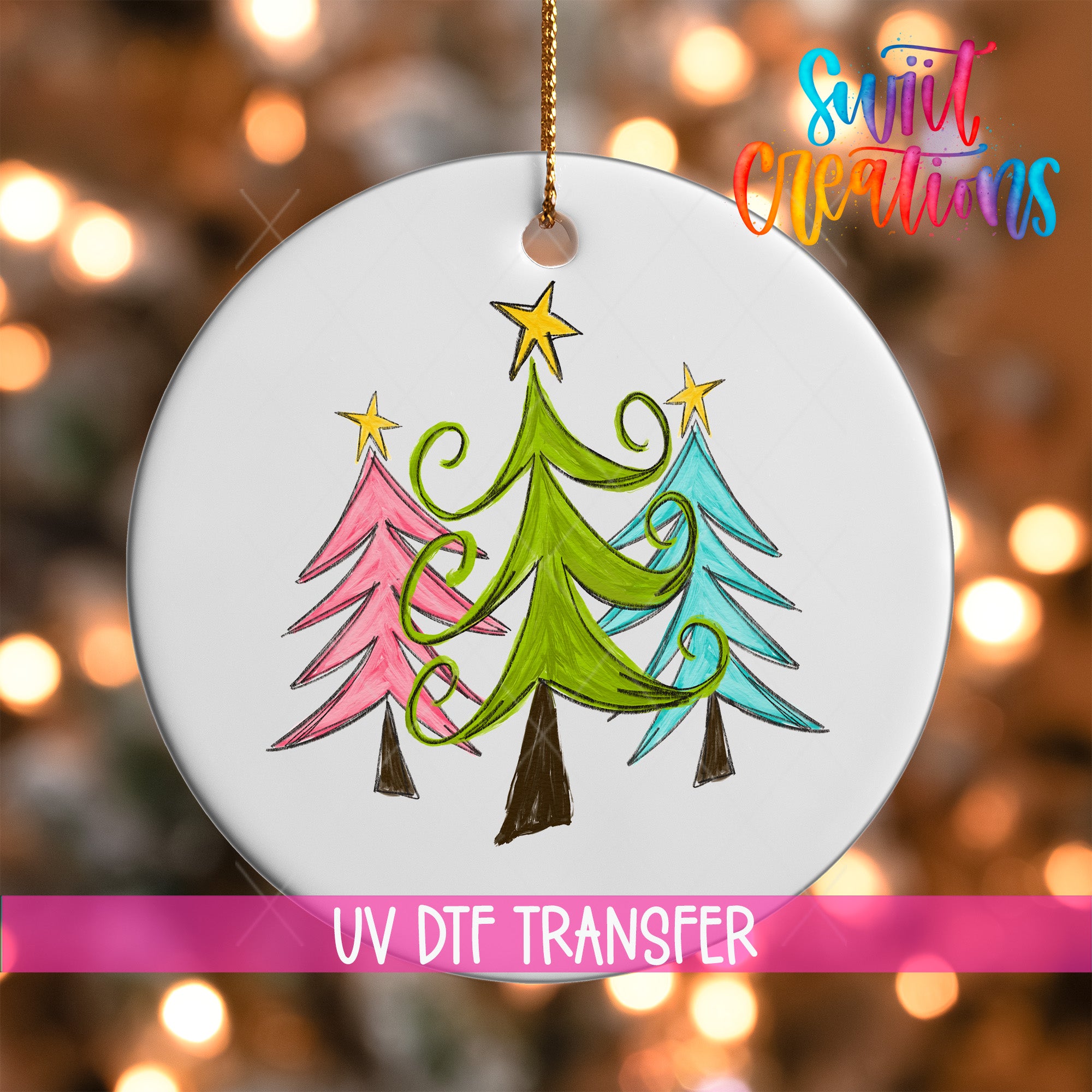 A white ornament with a drawing of three stylized Christmas trees in various colors, including green, pink, and blue, hanging from a string.