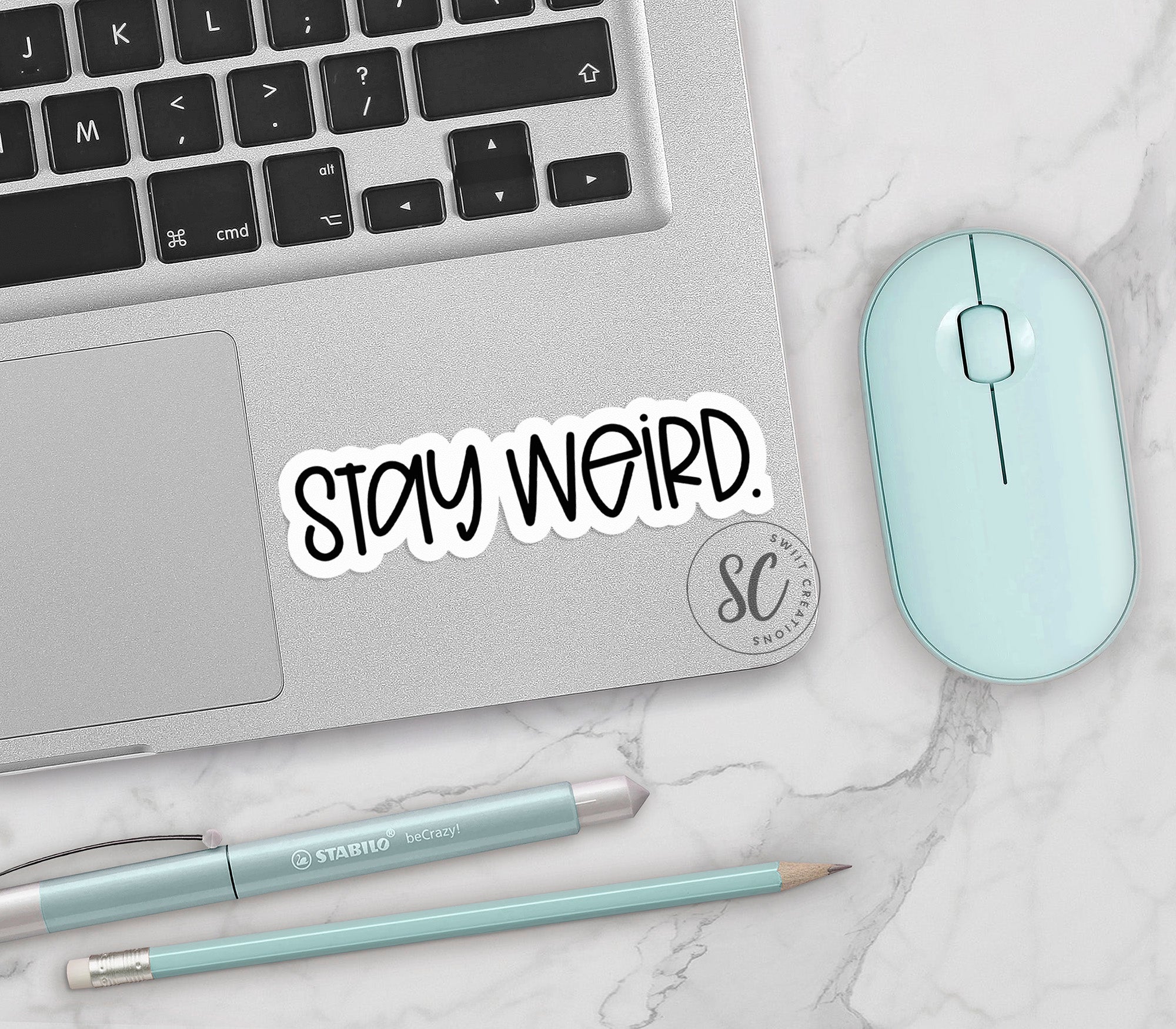 a laptop with a sticker that says stay weird