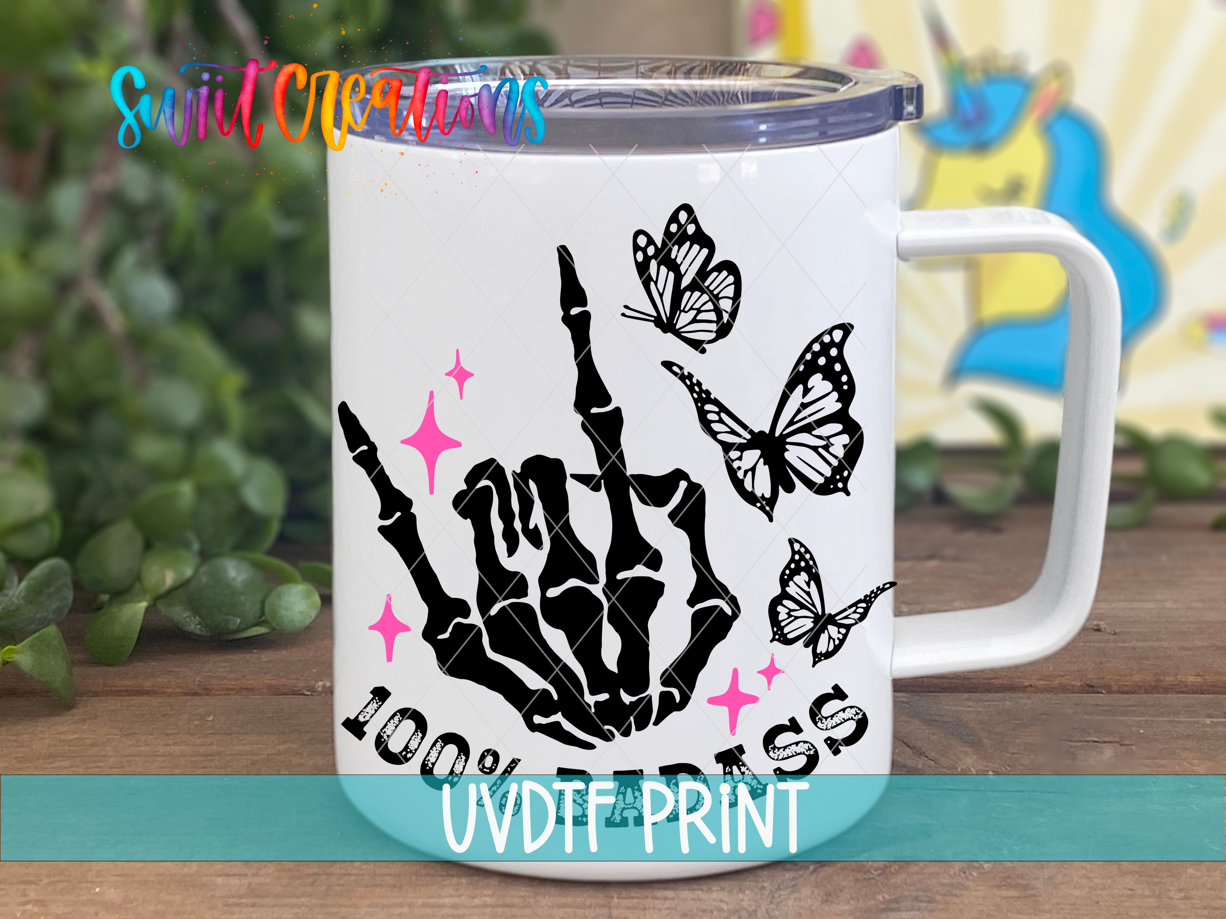 A white ceramic mug with a black and pink design featuring a skeleton hand and butterflies, along with the text "100% PRESS" printed on it.