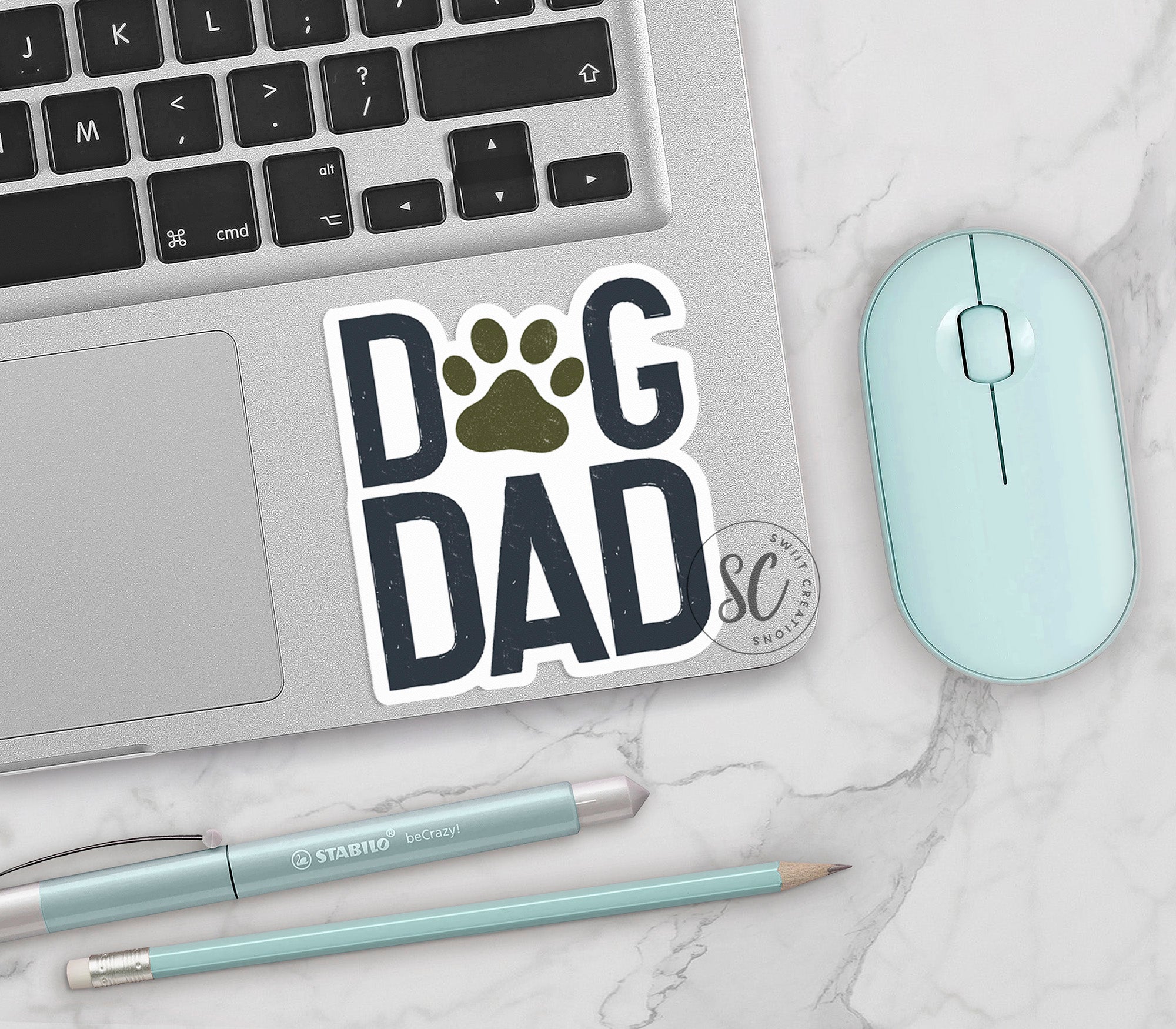 a laptop with a sticker of a dog's paw next to a mouse