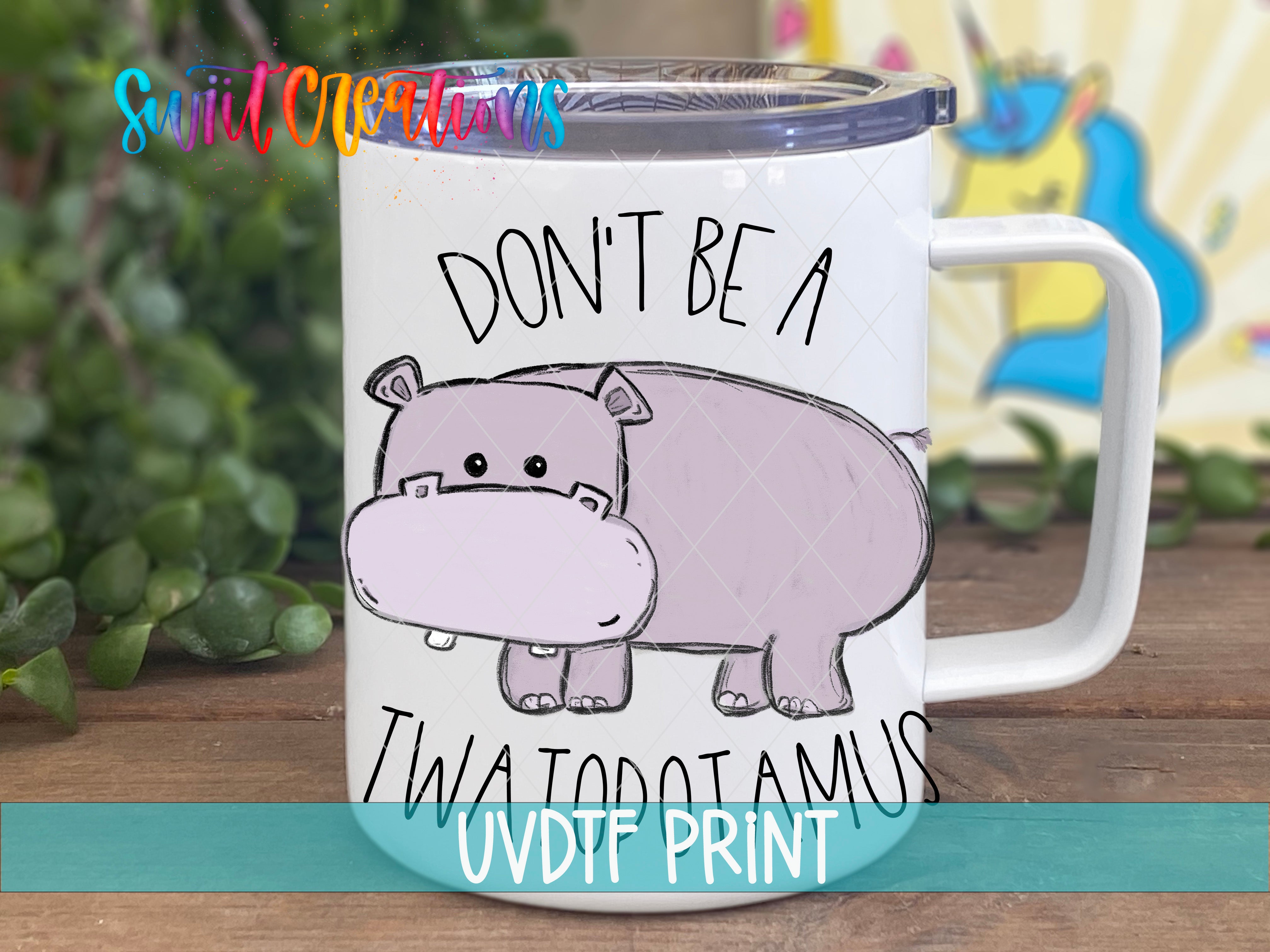 A white mug with a cartoon image of a hippopotamus and the text "DON'T BE A TWATOPAMUS" printed on it.