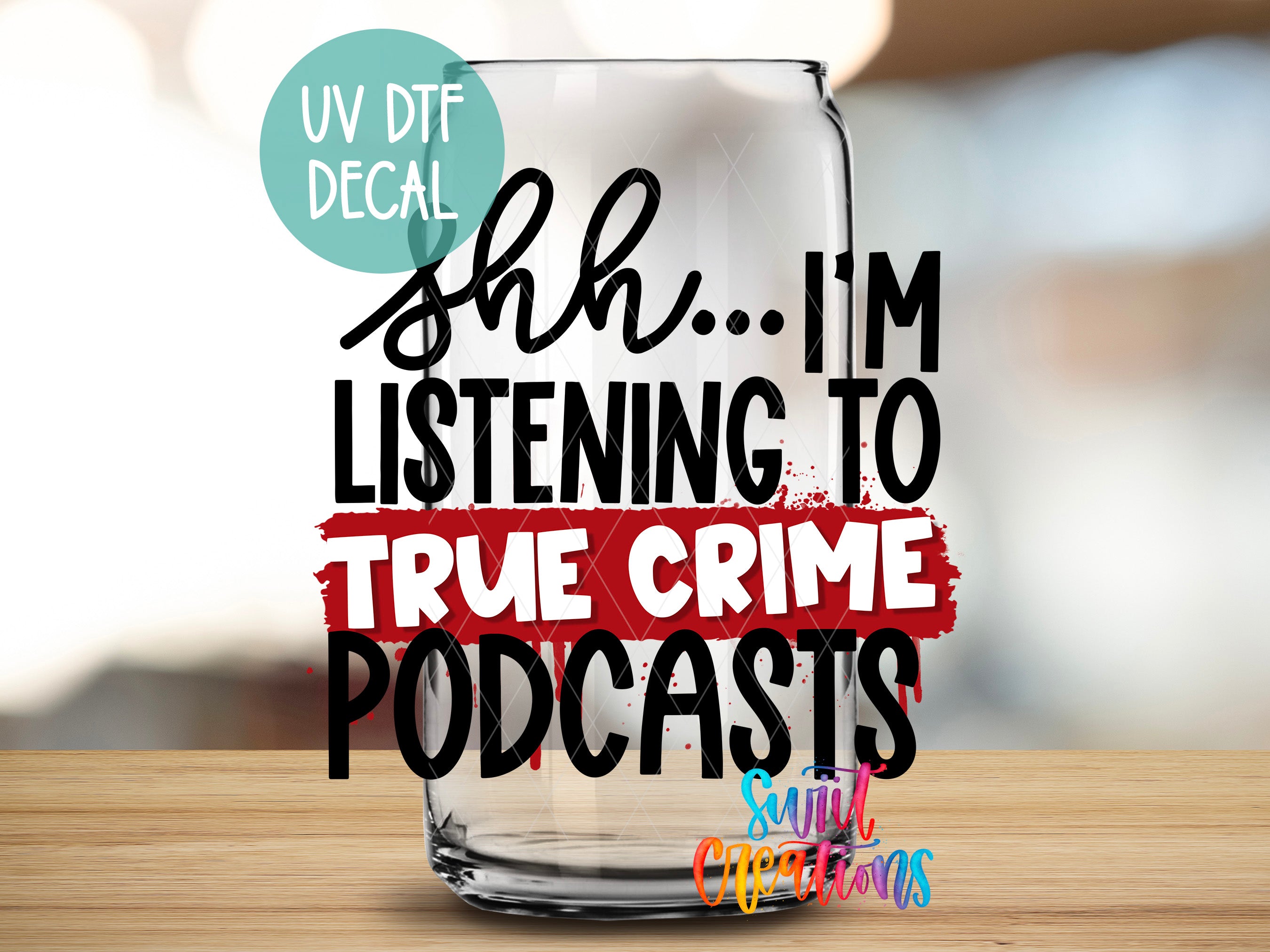 a glass with text on it, placed on a wooden surface.