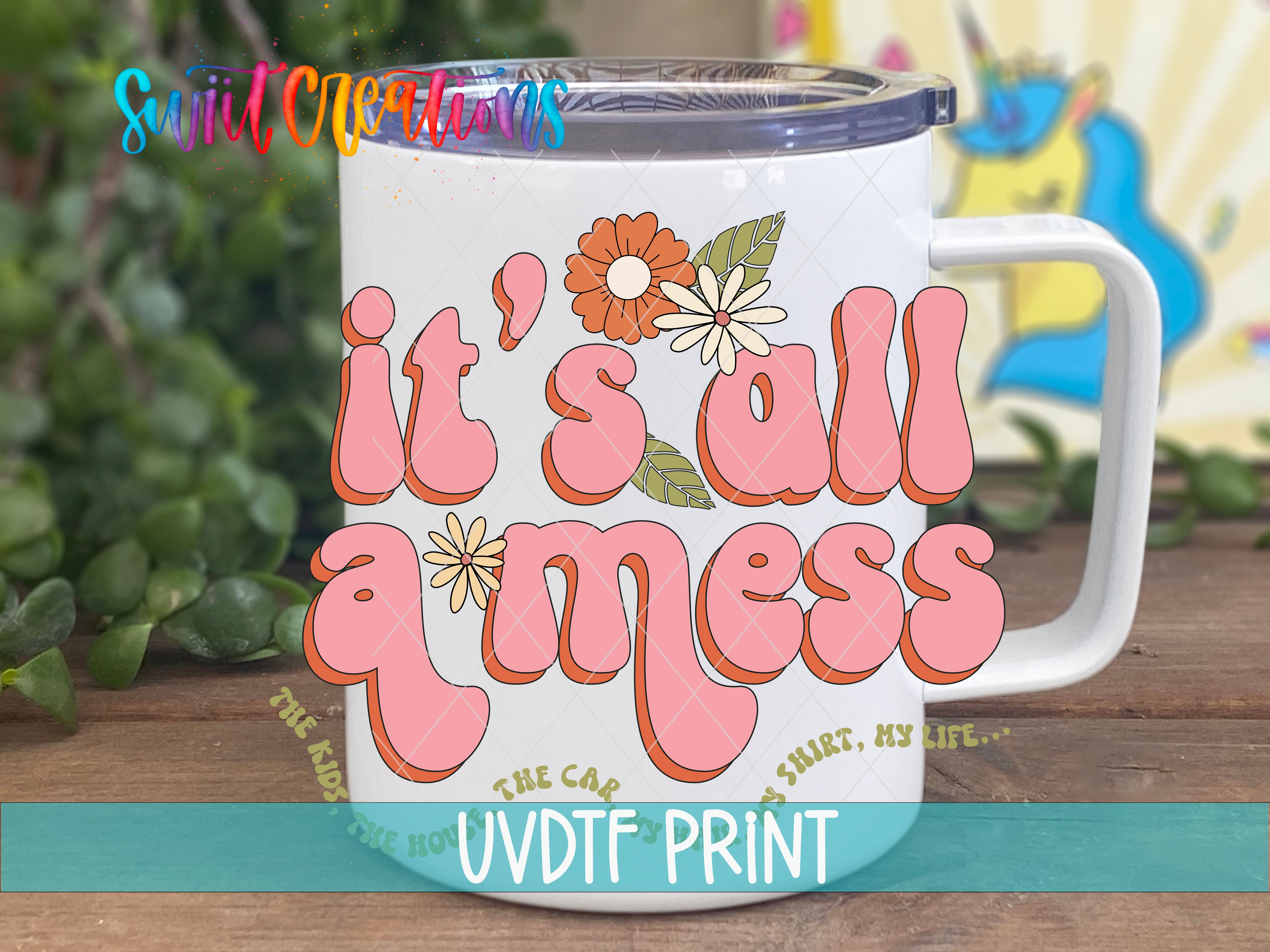 A white mug with colorful text and floral designs on it, placed on a wooden surface.