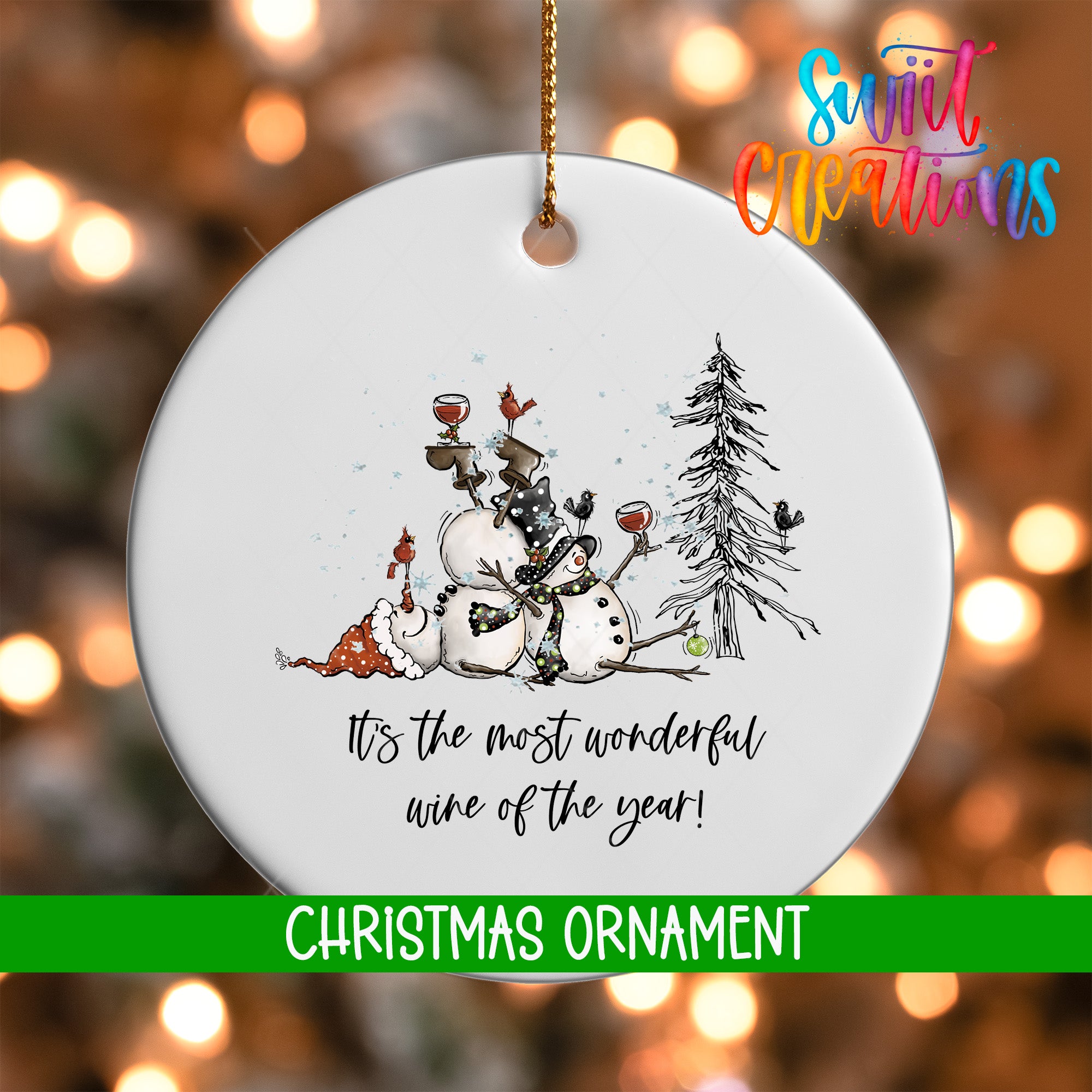 A white Christmas ornament with a snowman, a tree, and wine glasses, along with the text "It's the most wonderful wine of the year!"