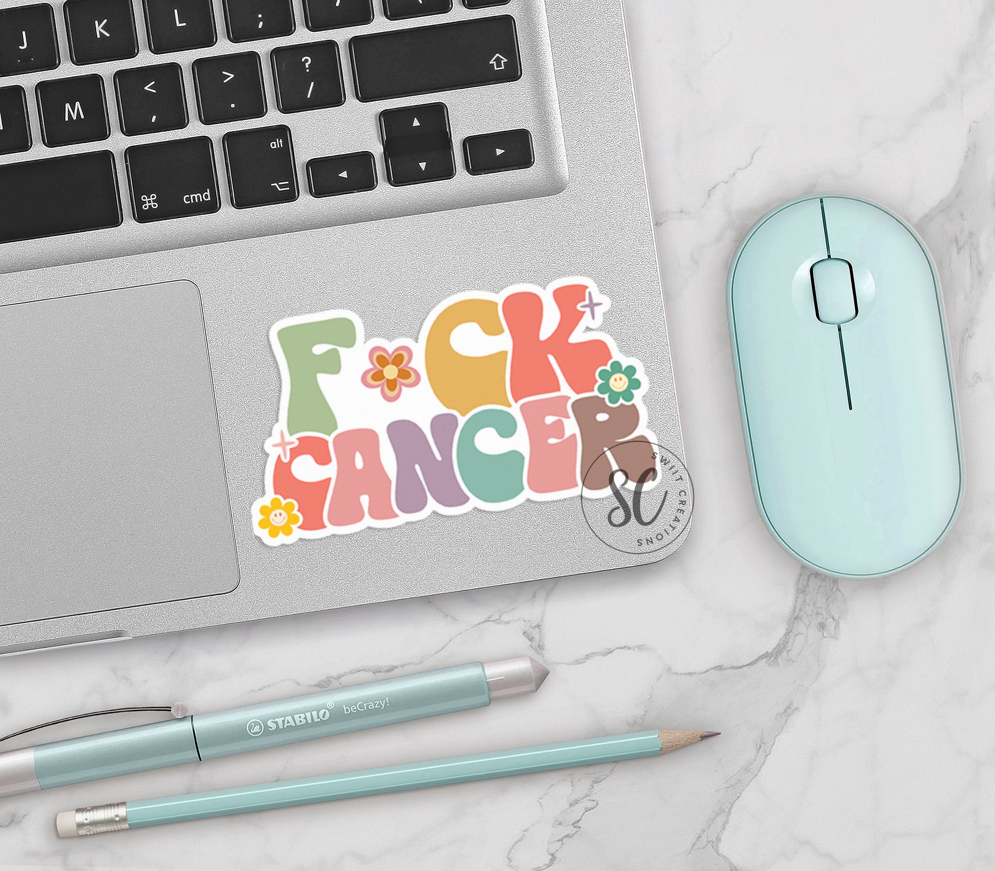 a sticker that says f k cancer next to a mouse and keyboard