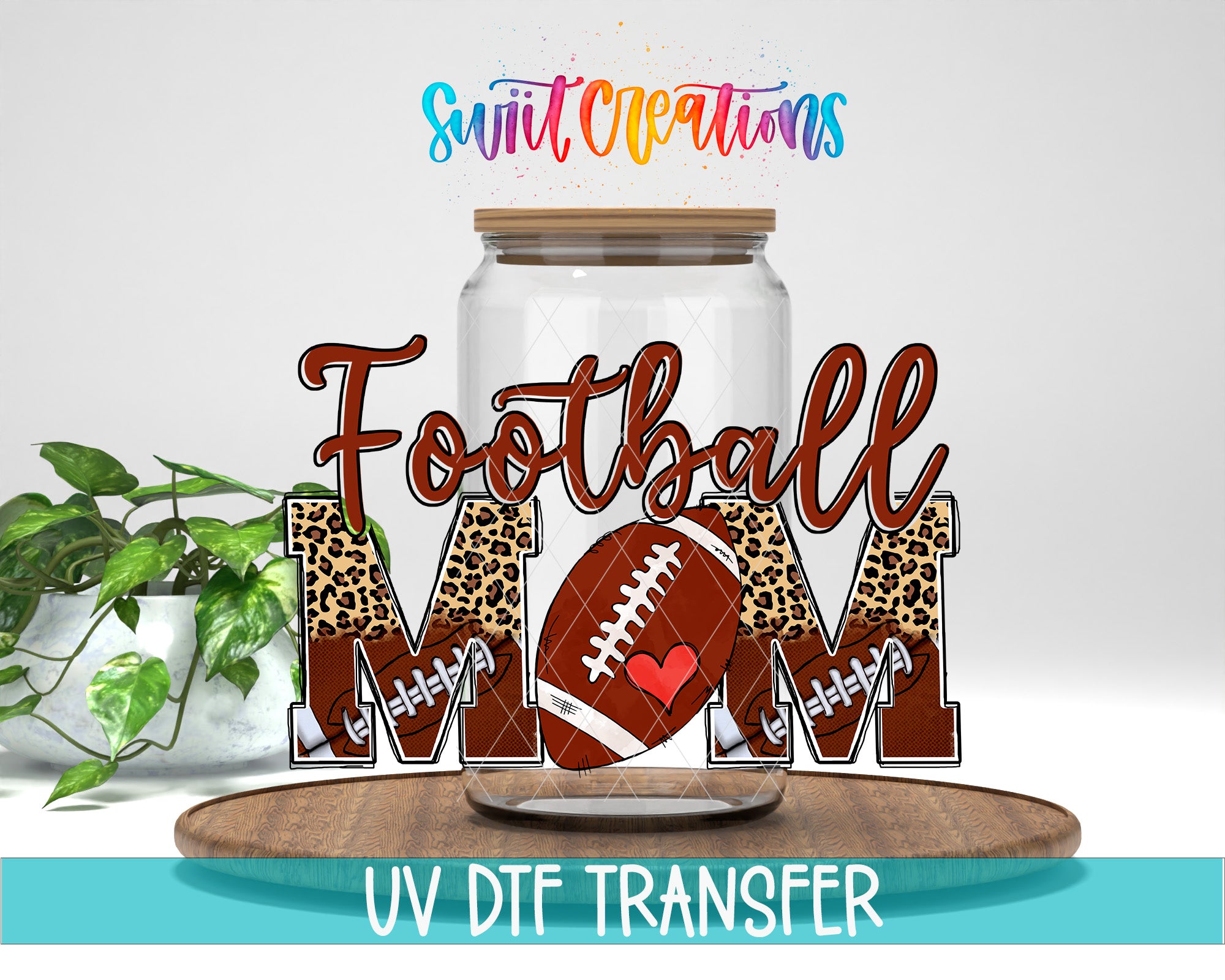 A glass jar with the word "Football Mom" written on it, along with a football graphic and leopard print lettering. The jar is placed on a wooden surface, and there is a plant in the background.