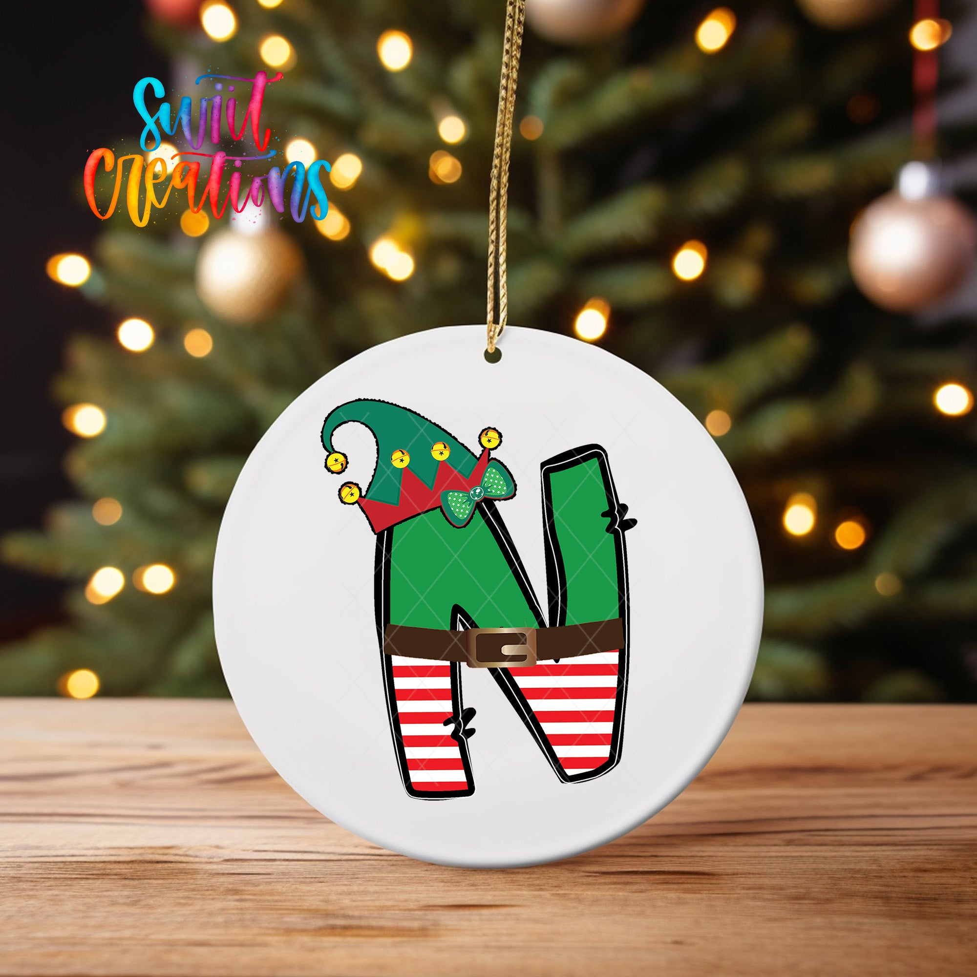 A white ornament with a green elf hat and striped red and white pants, representing the letter "N" on a Christmas tree.