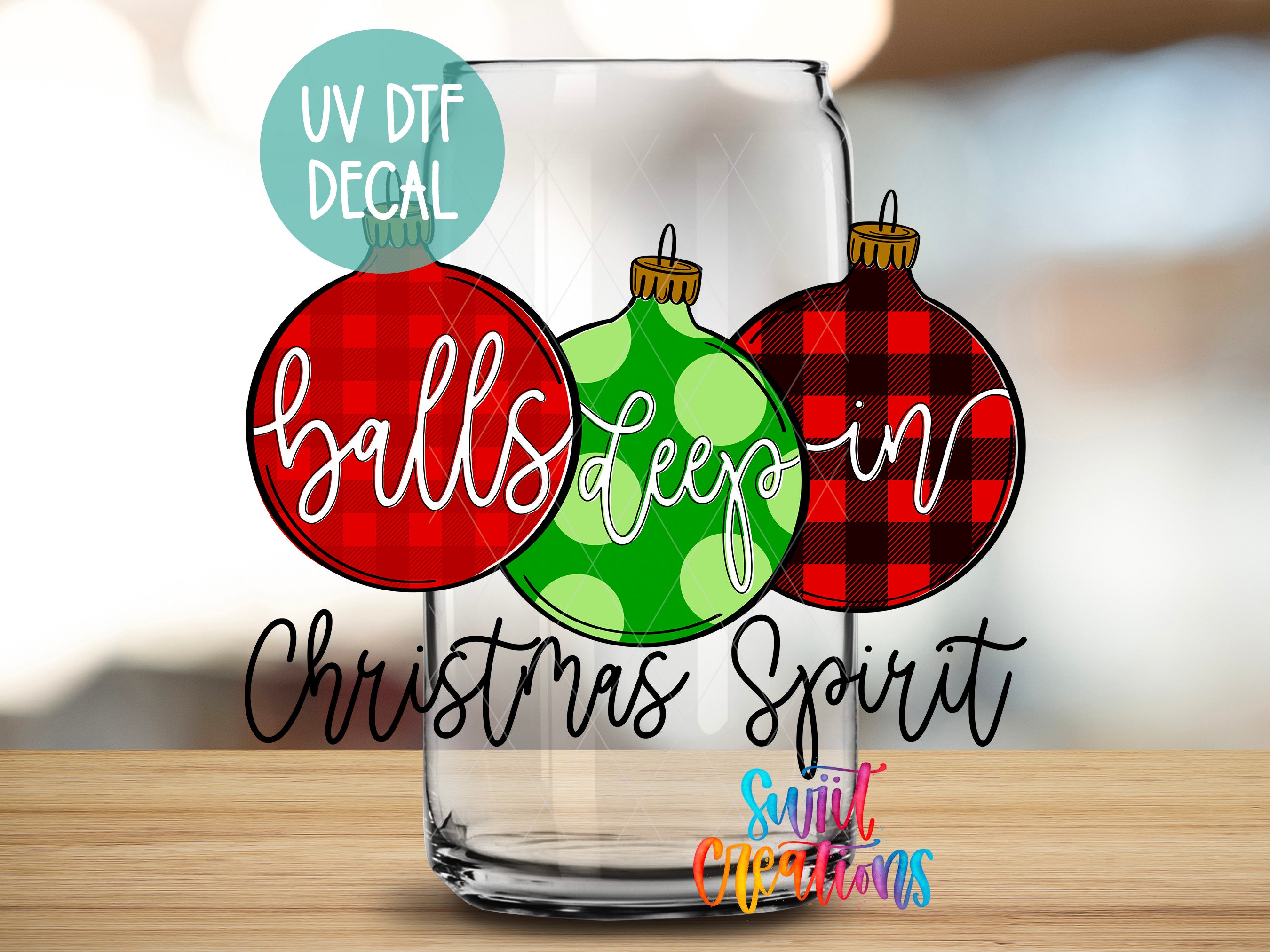 A glass with three Christmas ornaments, each with a different color and pattern, along with the text "balls deep" and "Christmas Spirit" written on it.