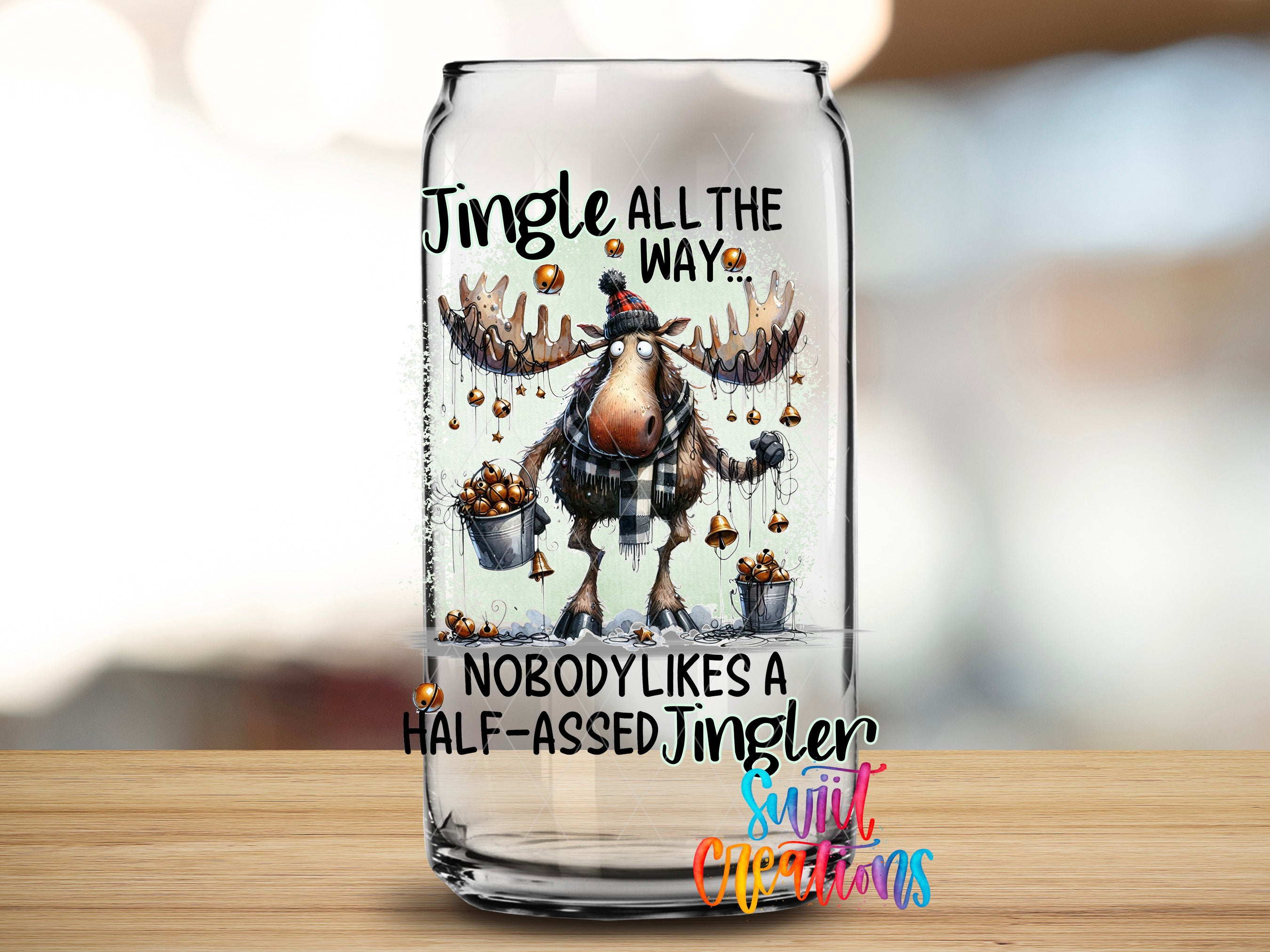 A glass can with a jingle all the way cartoon moose holding a bucket of Christmas ornaments.