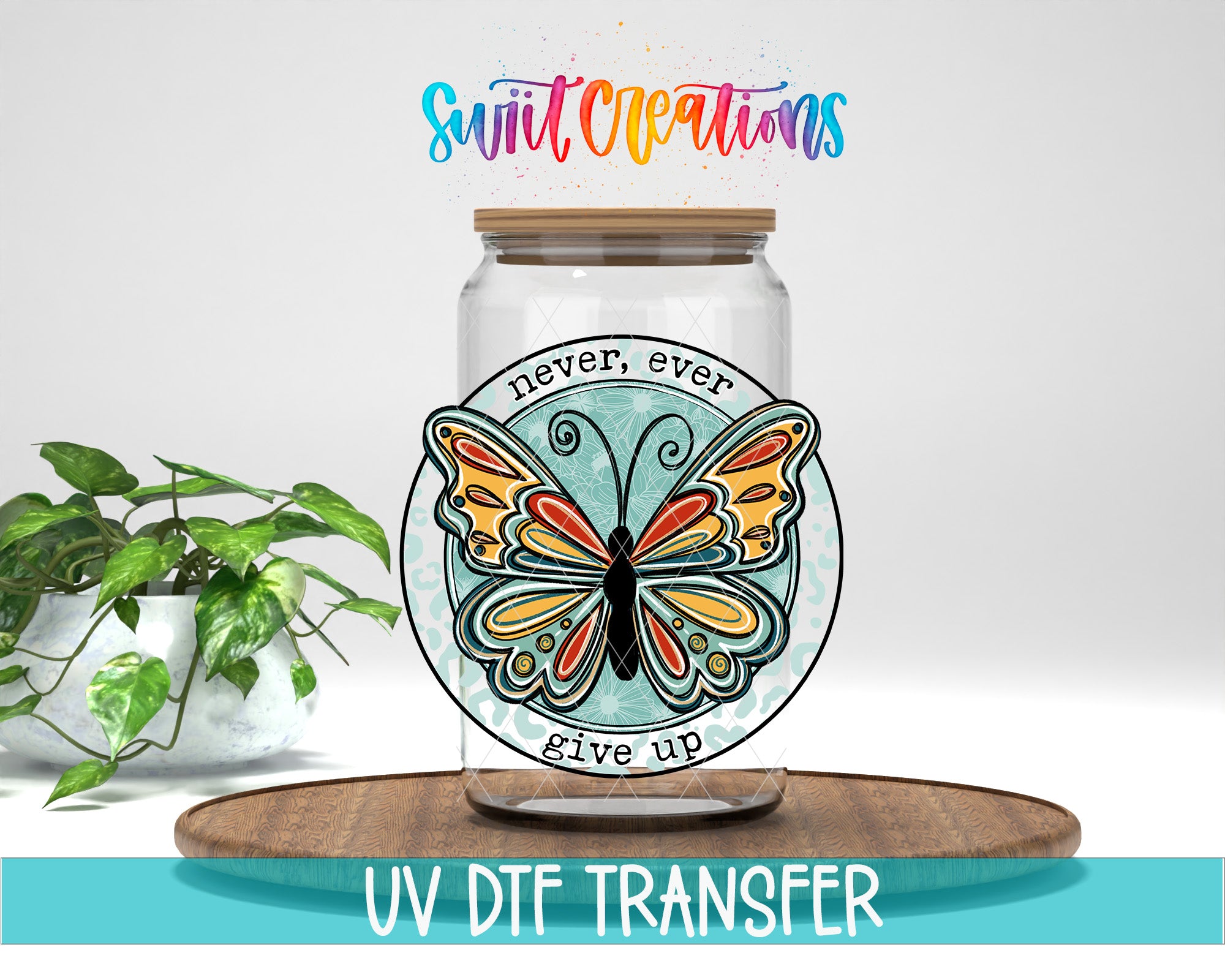 a glass jar with a butterfly design, placed on a wooden surface. Above the jar, there is a colorful text that says "Swift Creations never, ever give up". The jar is placed next to a potted plant, and there is a wooden tray in the foreground.
