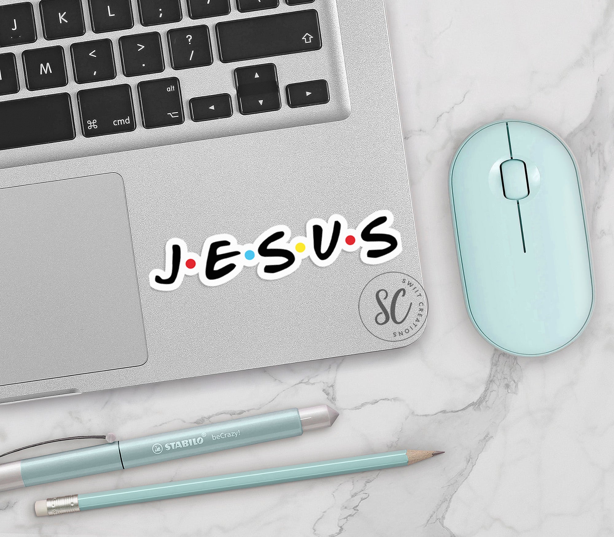 a laptop with a sticker that says jesus next to a mouse