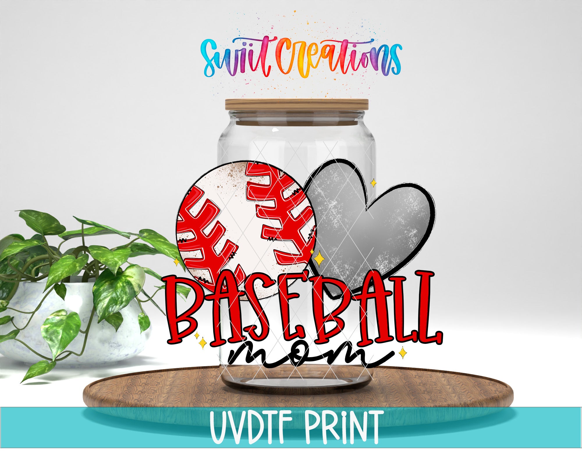 a baseball-themed design with a baseball and a heart, along with the text "Baseball mom" and "Swift Creations" written above. The background is a plain white wall, and there is a potted plant to the left of the image.