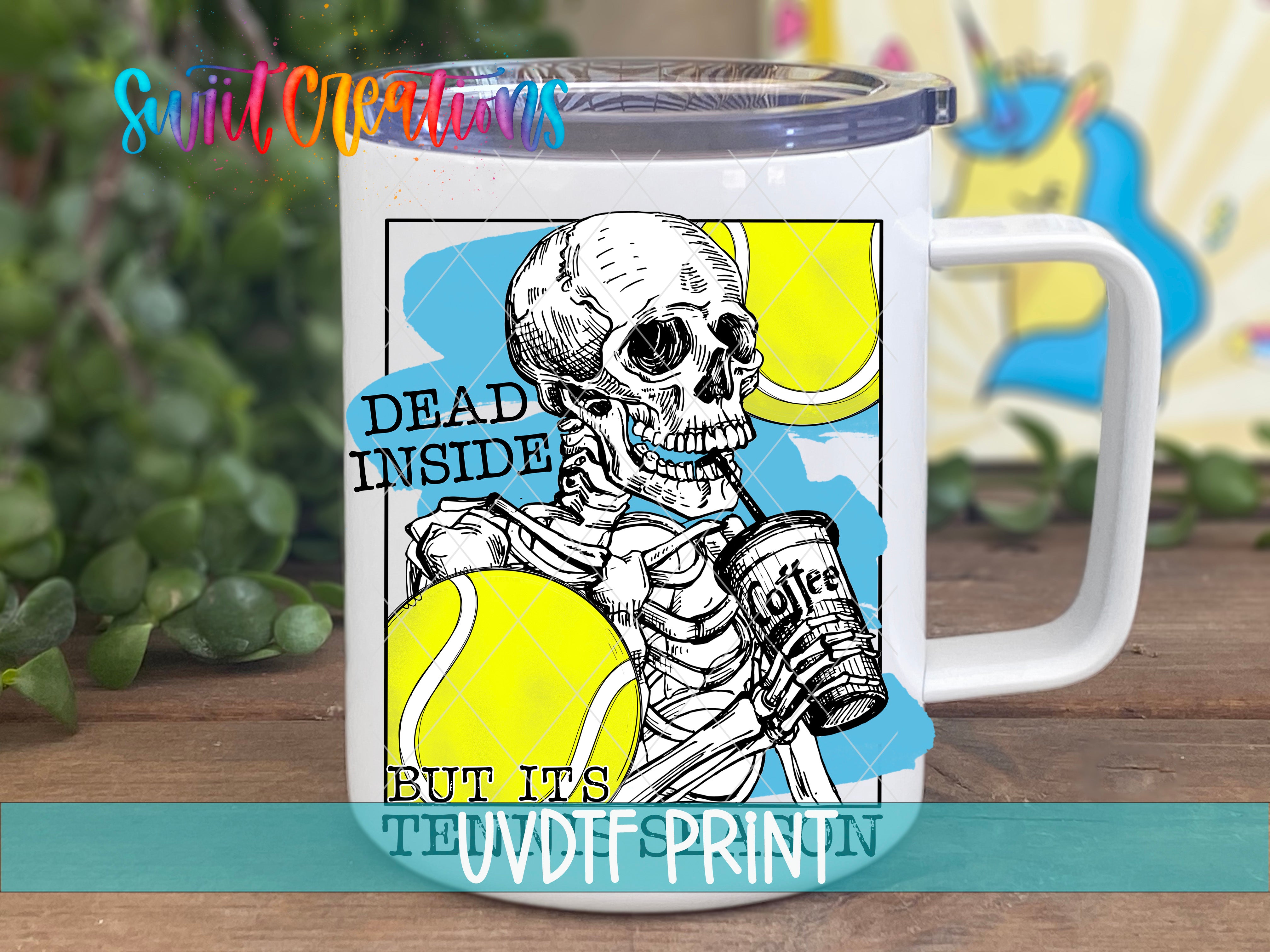 A white mug with a printed design featuring a skeleton holding a can of coffee and tennis balls.