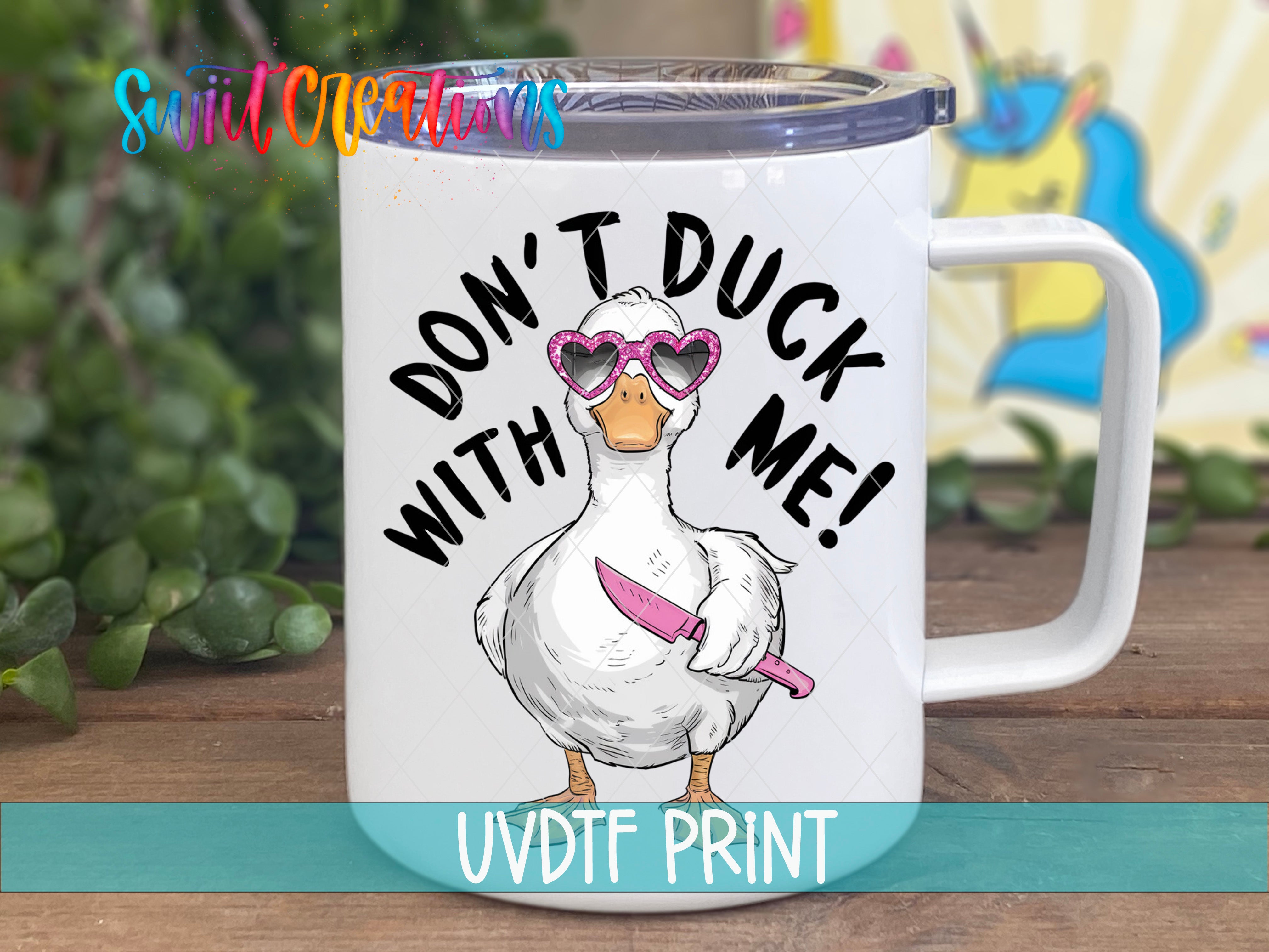 A white mug with a cartoon duck wearing sunglasses and holding a knife, along with the text "DON'T DUCK WITH ME!" printed on it.