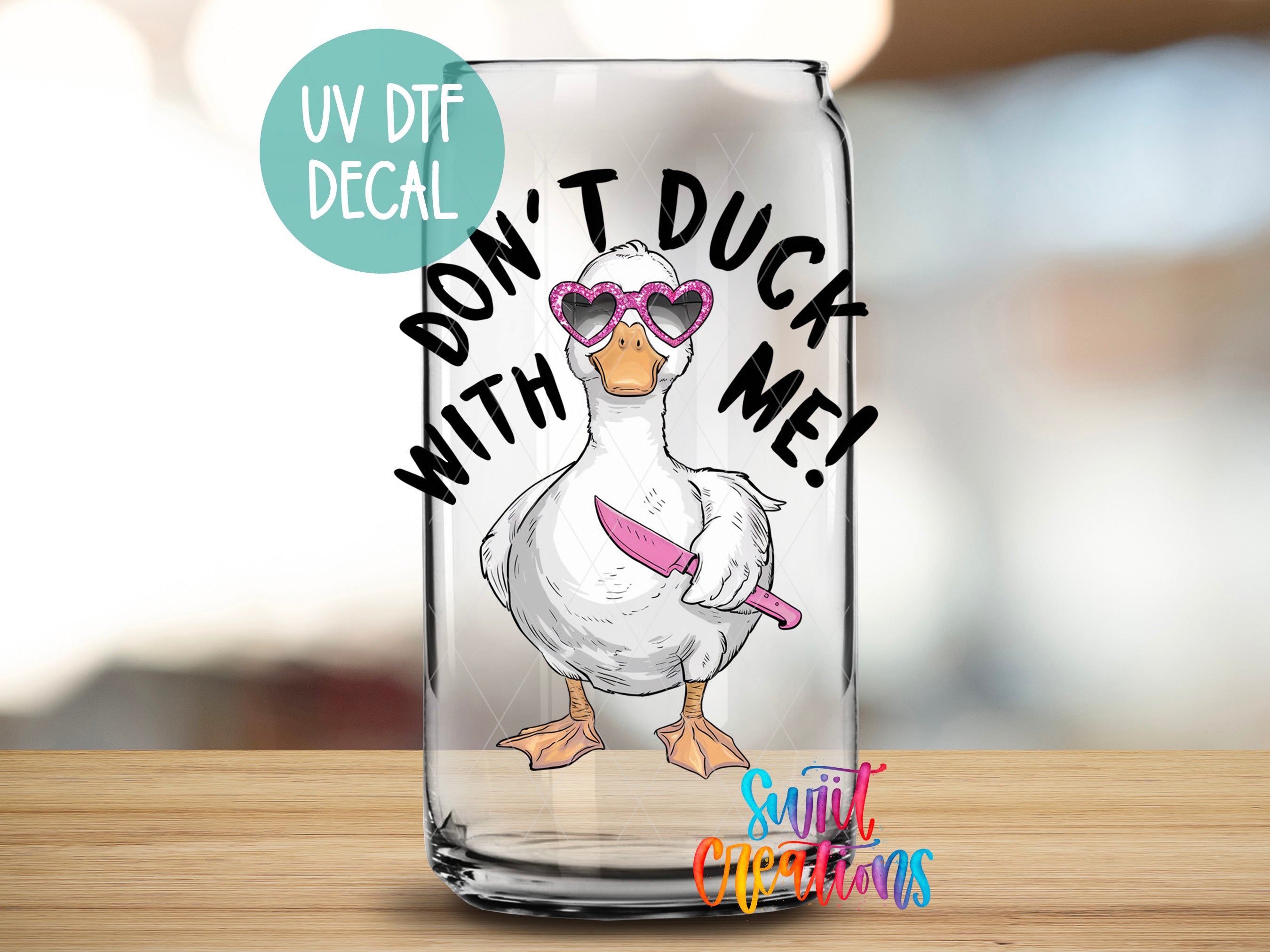 A glass can with a cartoon duck wearing sunglasses and holding a knife, with the text "DON'T DUCK ME!" printed on it.