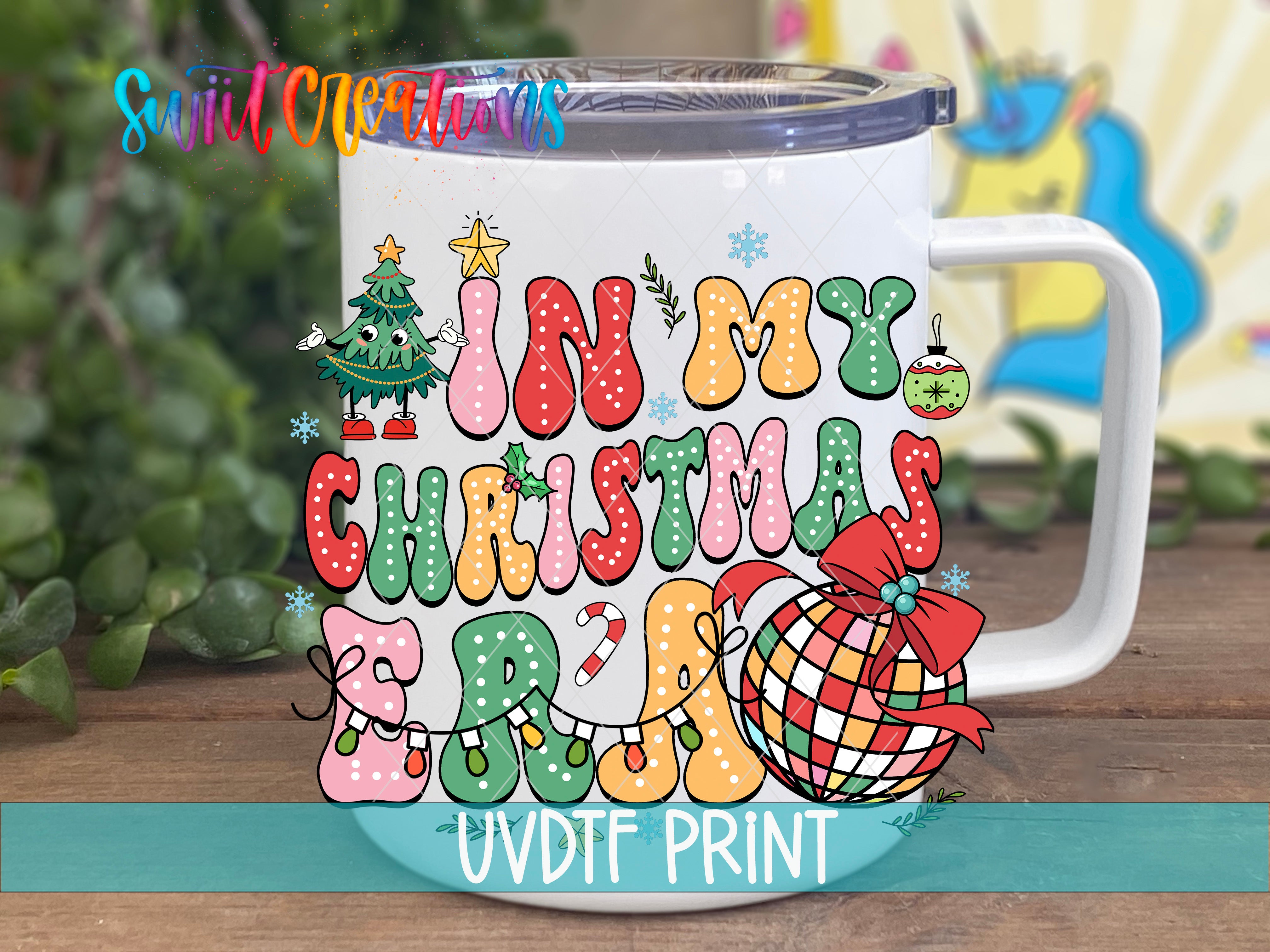 A white mug with a colorful, festive design featuring Christmas-themed elements such as a Christmas tree, snowflakes, and a ball.