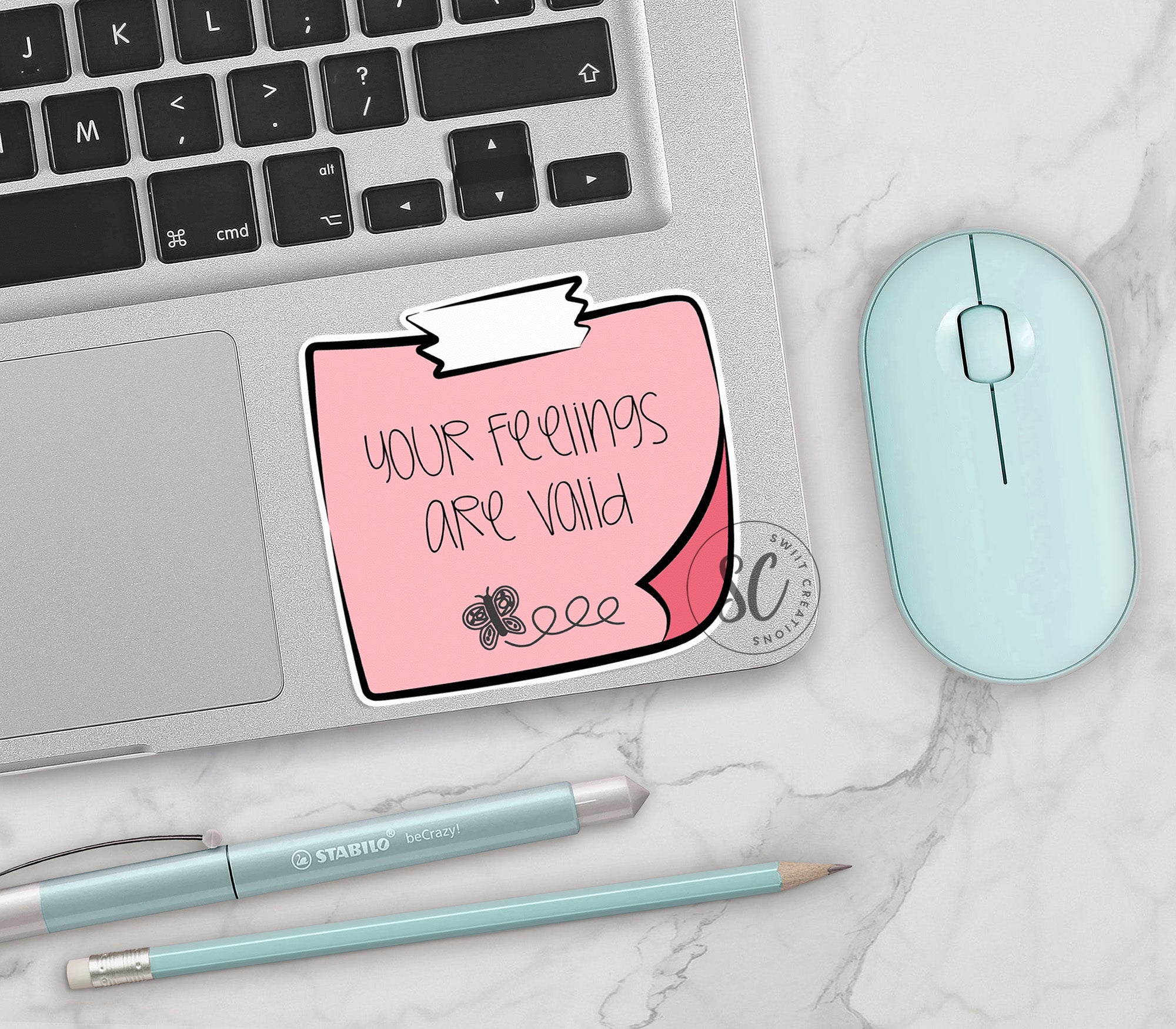 a laptop with a sticker on it next to a mouse