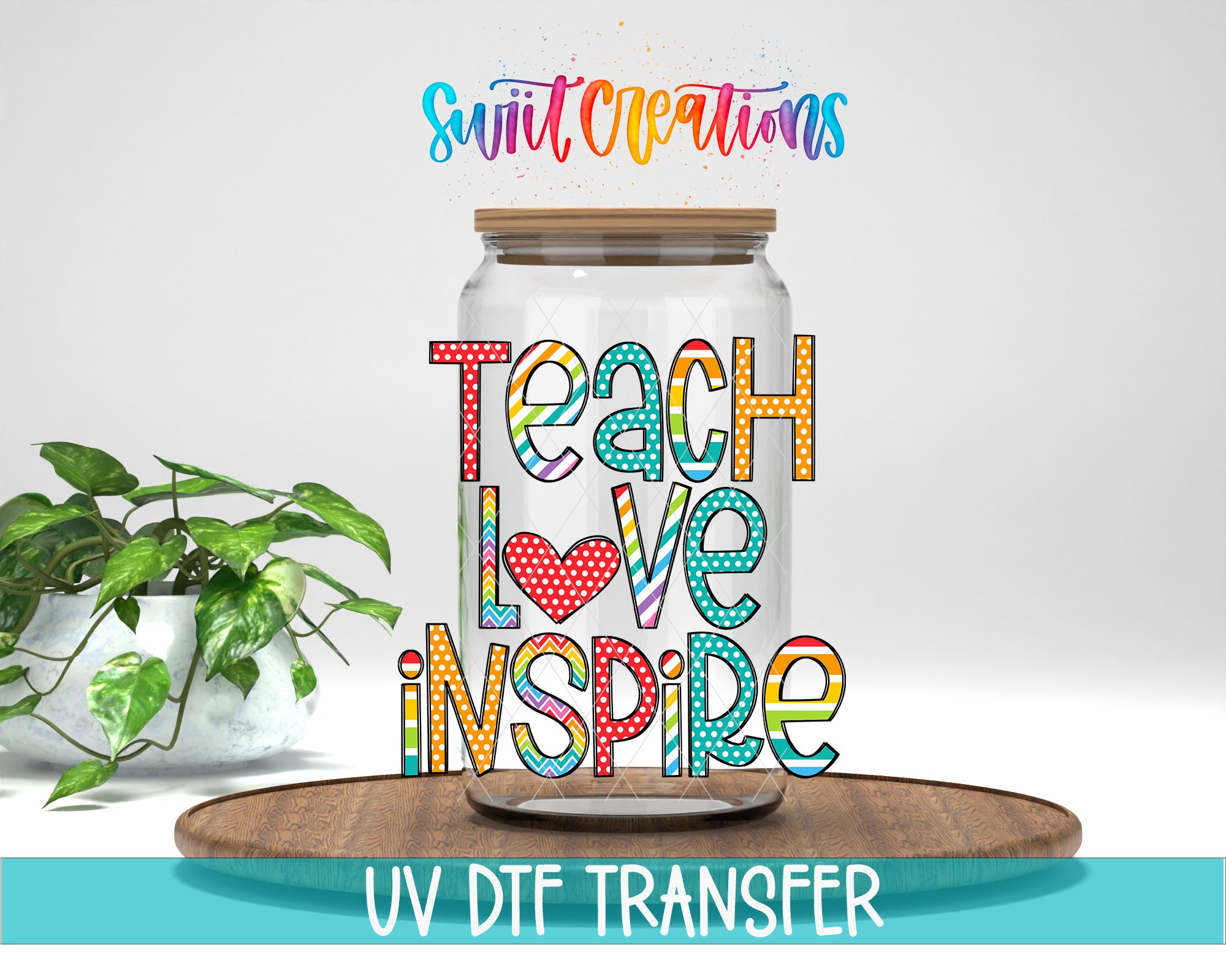 a glass jar with colorful text on it, placed on a wooden surface. The text on the jar says "Teach Love Inspire".