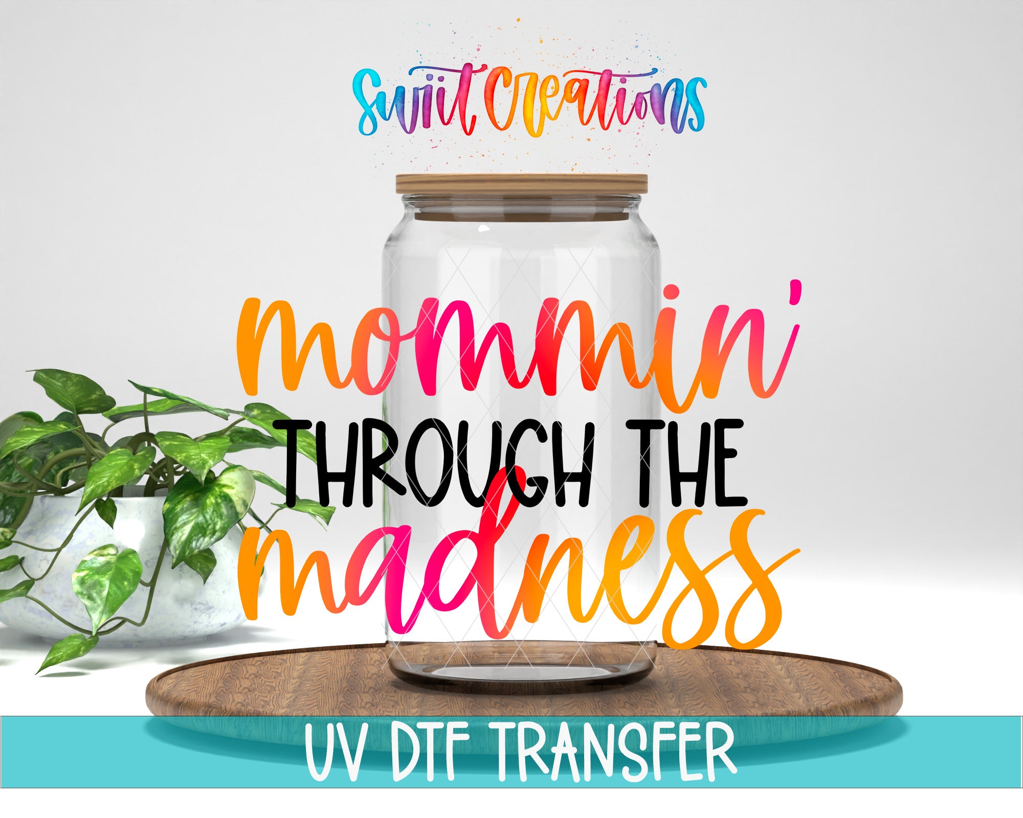 a glass jar with a wooden lid, placed on a wooden surface, with a potted plant in the background. The text overlay on the image reads "swift creations mommin' through the madness UV DFT Transfer".