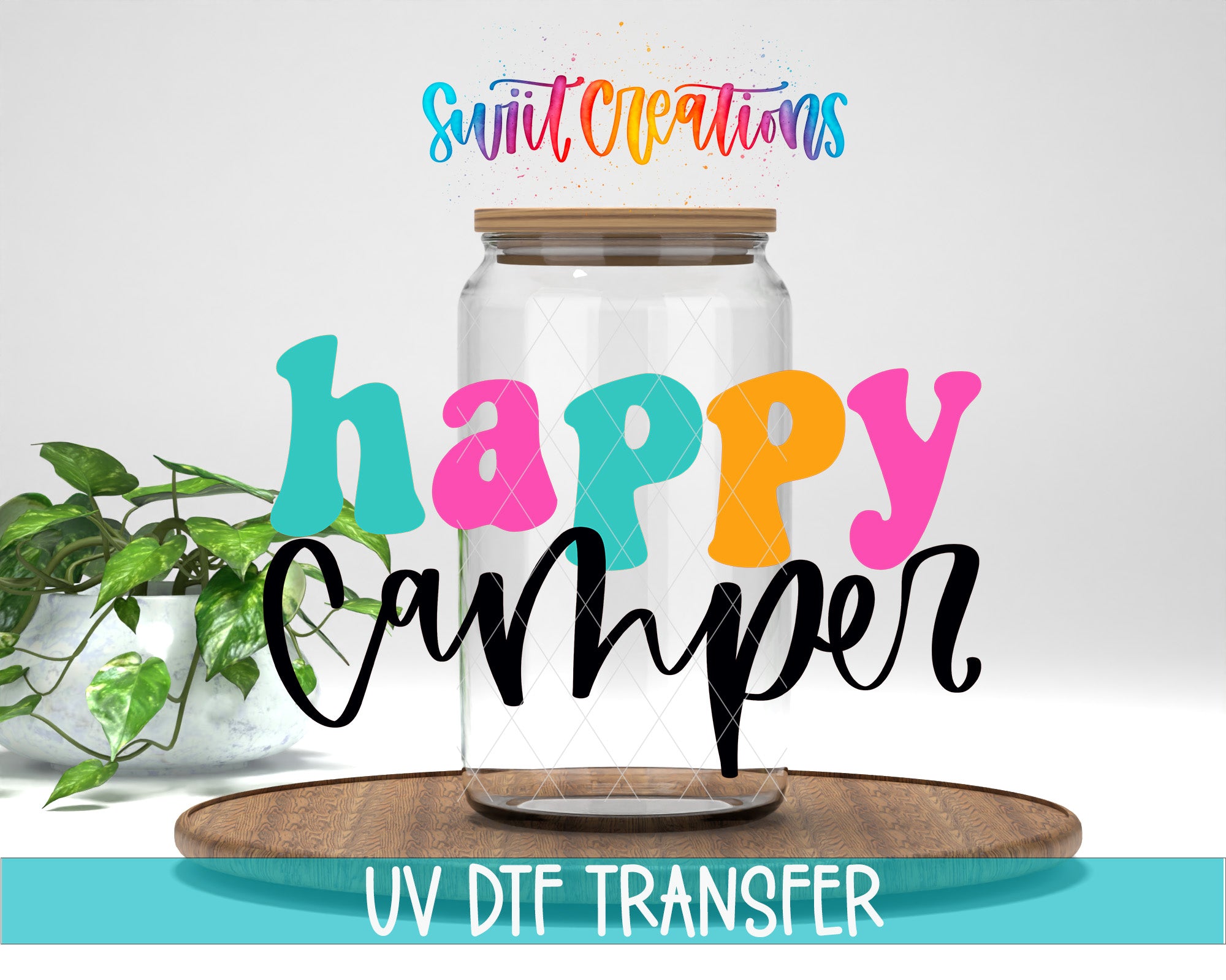 a clear glass jar with a wooden lid, surrounded by colorful text that reads "Happy Camper" and "Swit Creations". The jar is placed on a wooden surface, and there is a potted plant in the background.