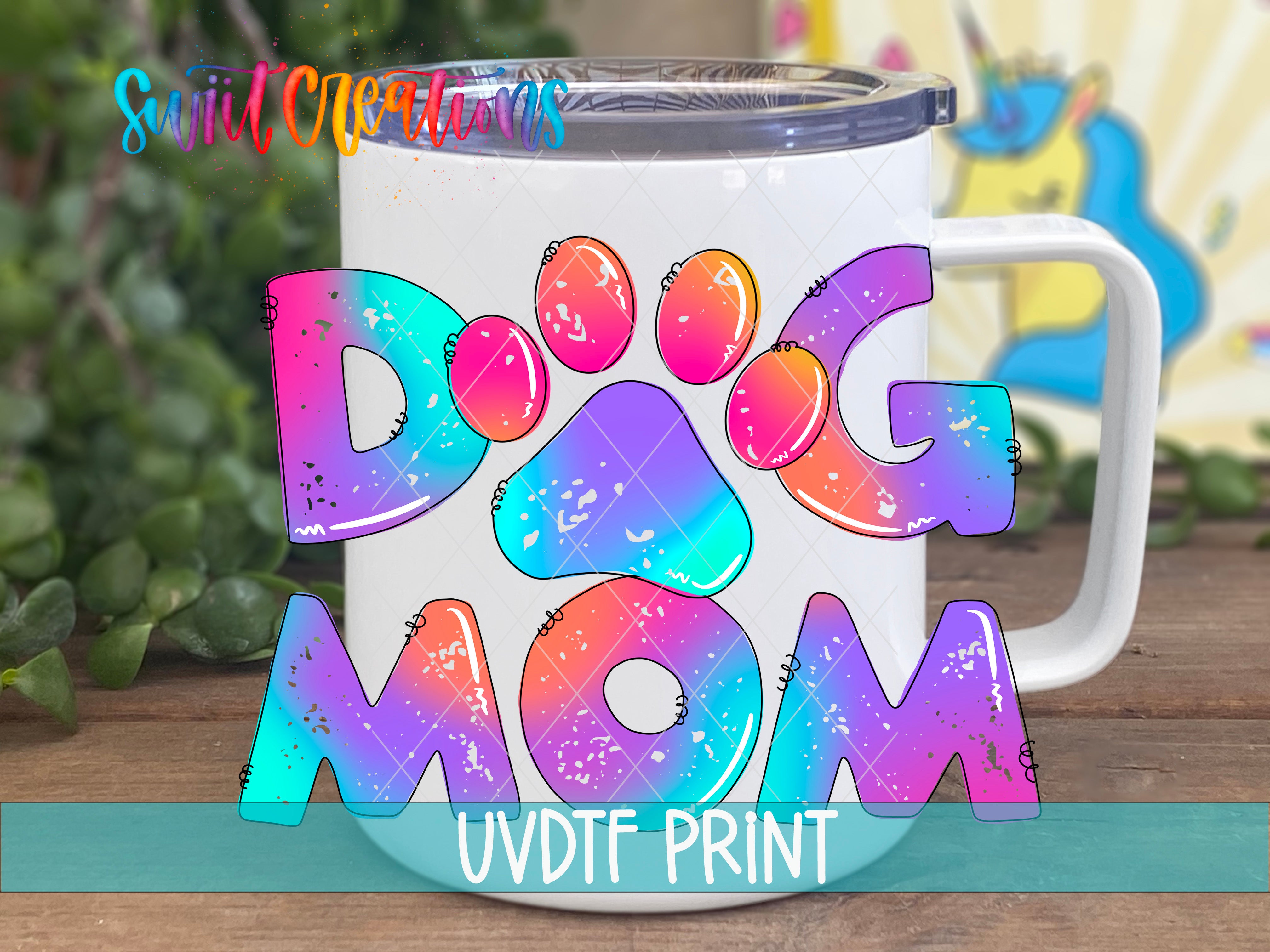 A colorful mug with the text "DOG MOM" printed on it, along with a unicorn illustration in the background.