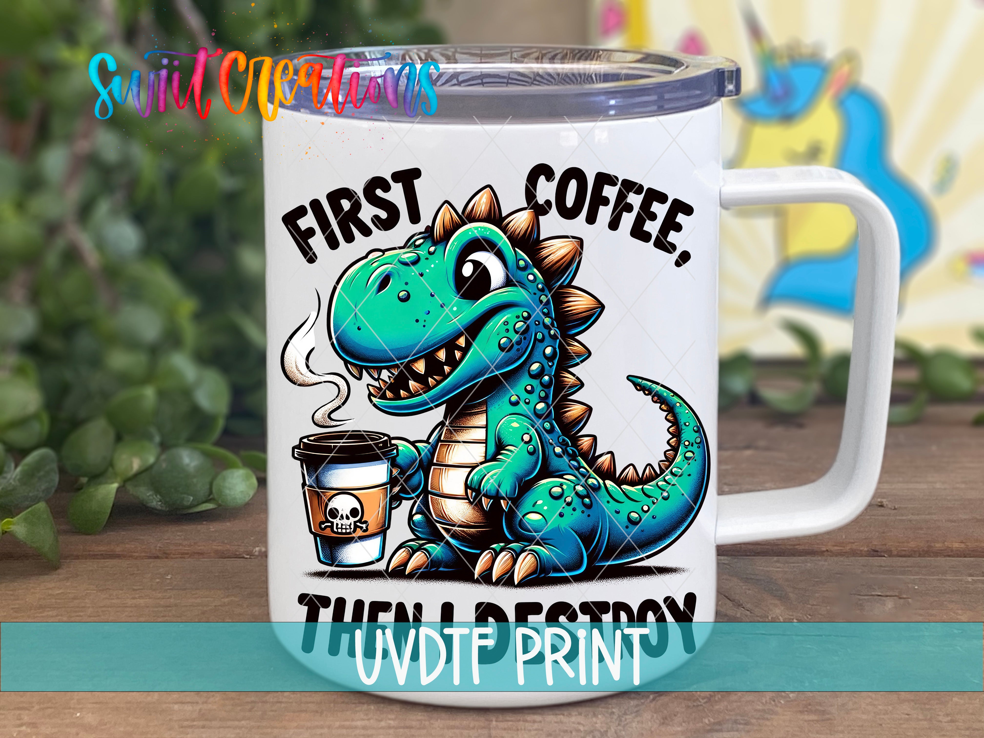 A white mug with a cartoon dinosaur holding a coffee cup and the text "FIRST COFFEE, THEN A DESTROY" printed on it.