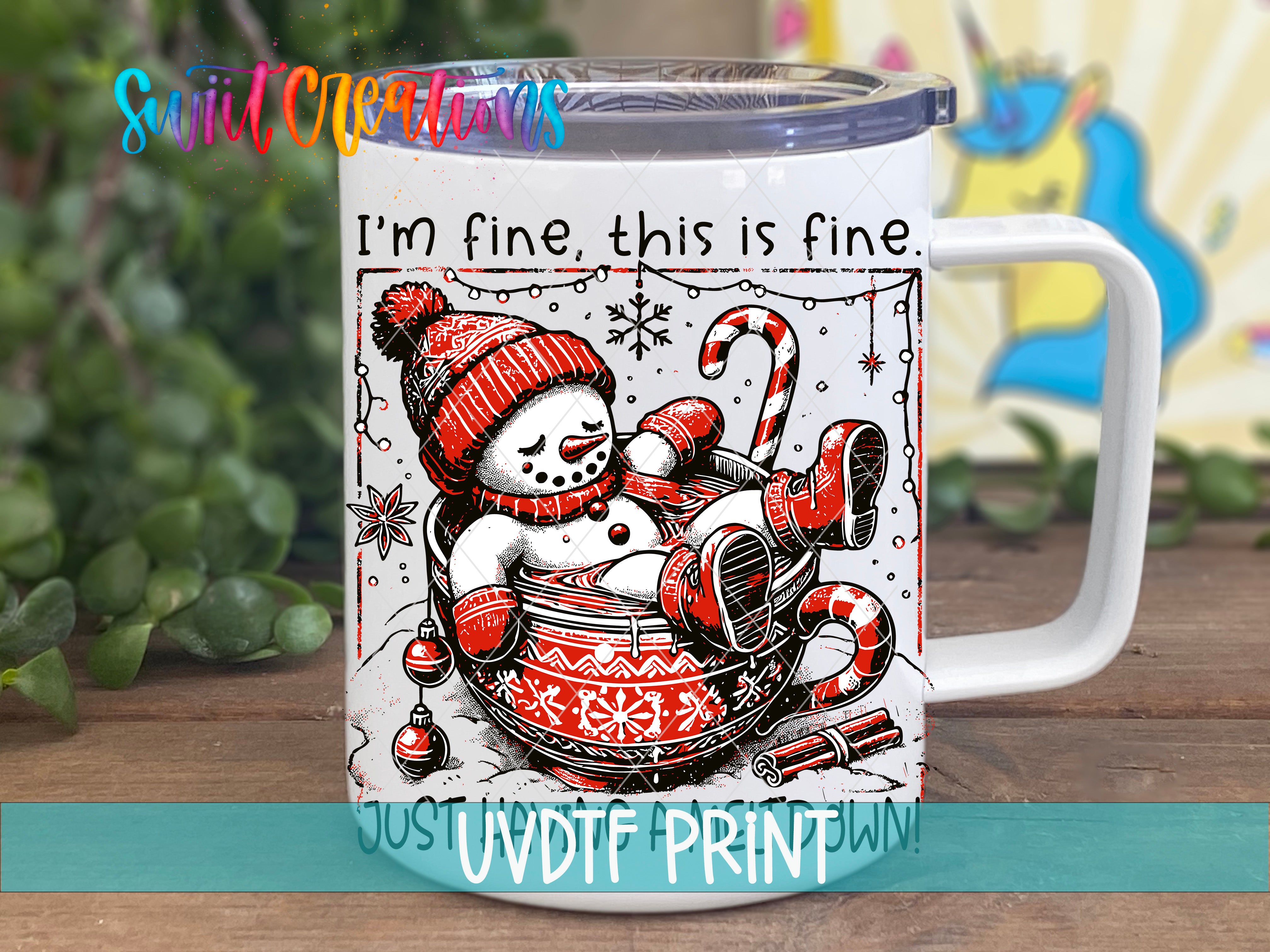 A mug with a snowman and a cup of hot chocolate, along with the text "I'm fine, this is fine" and "JOS UVDF PRINT".