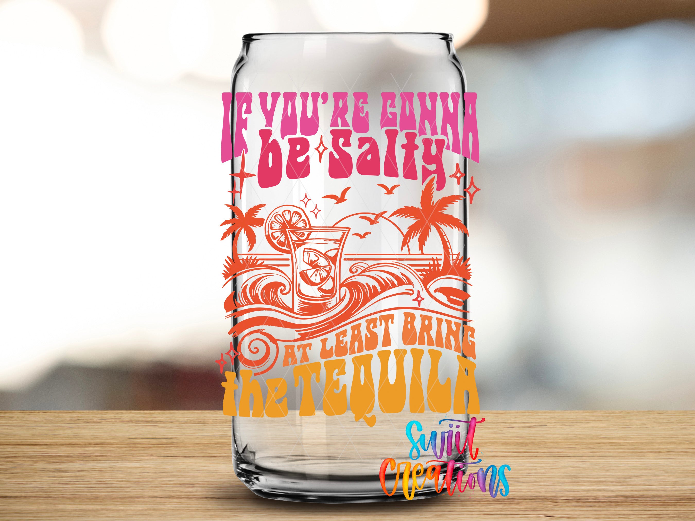 a clear glass can with a colorful design and text on it.