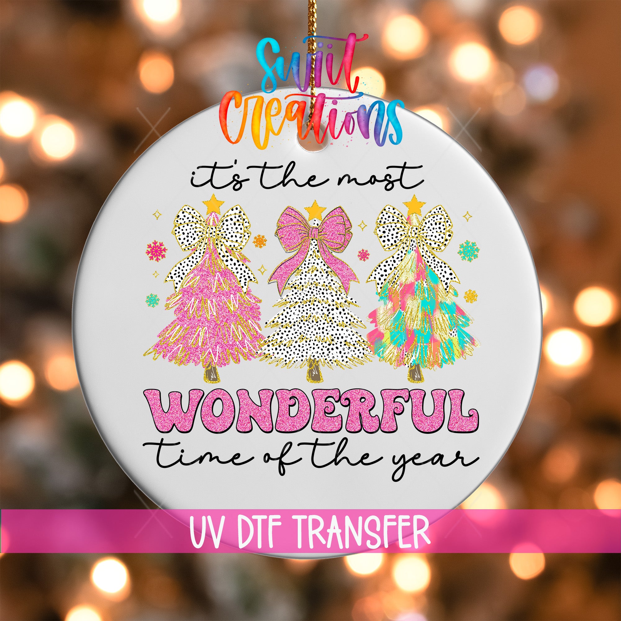 A white ornament with a festive design featuring three colorful Christmas trees and the text "It's the most wonderful time of the year" in a vibrant, whimsical style.
