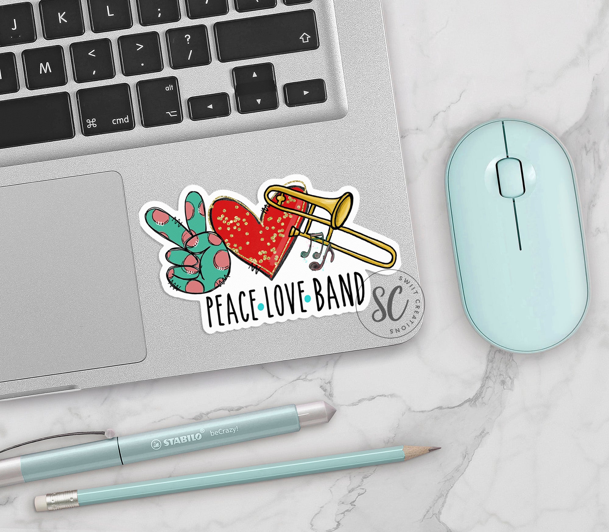a computer keyboard, mouse, and sticker with peace love band on it
