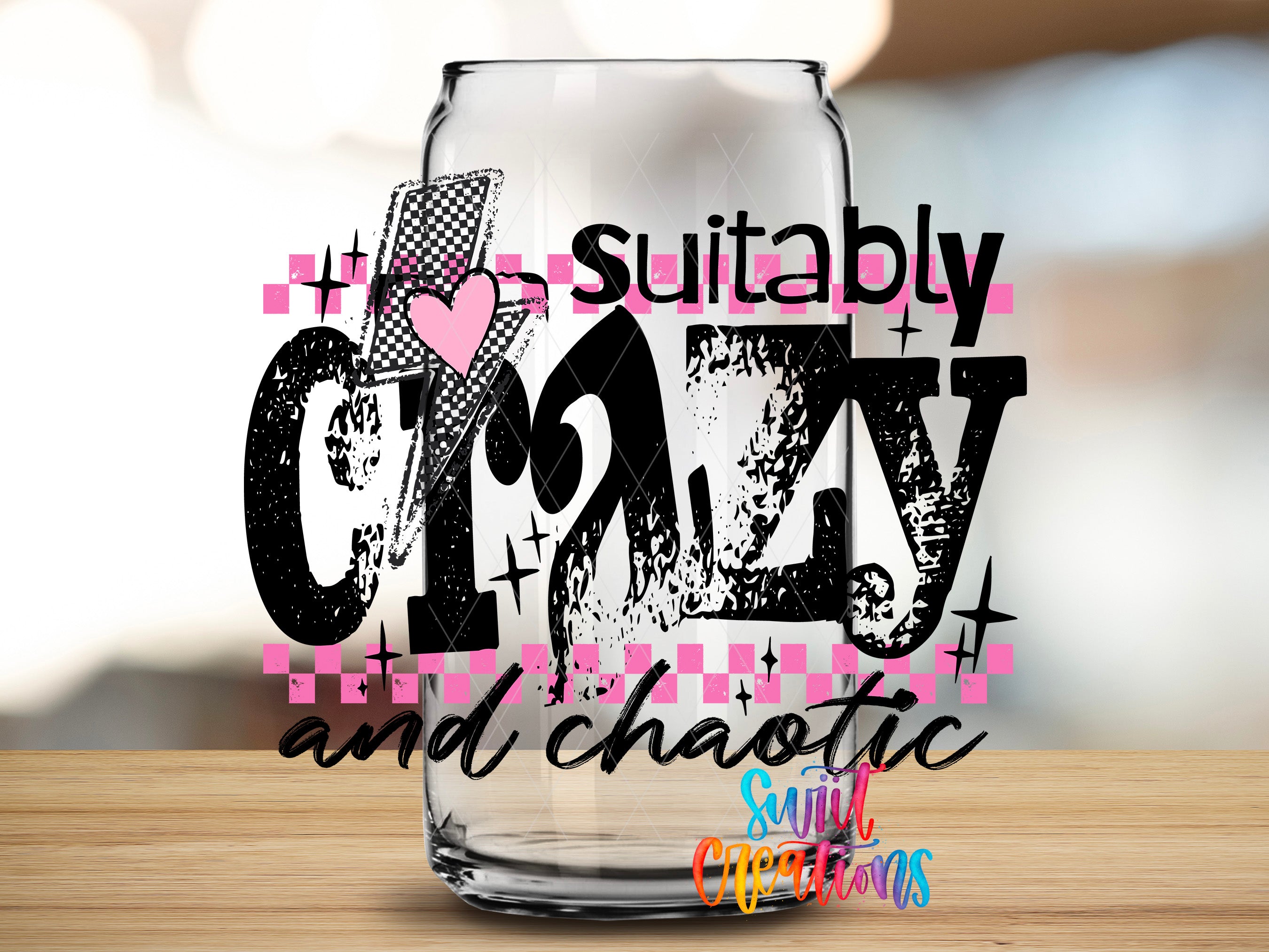 a glass with a stylized text design on it, which reads "suitably crazy and chaotic" in a bold, graphic font.
