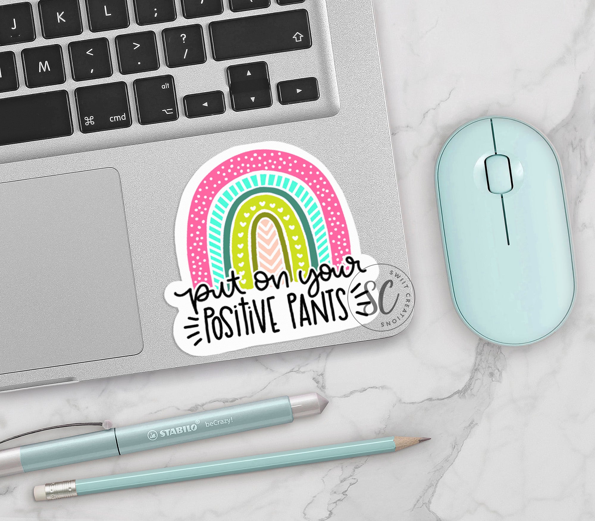 a laptop with a sticker on it next to a mouse